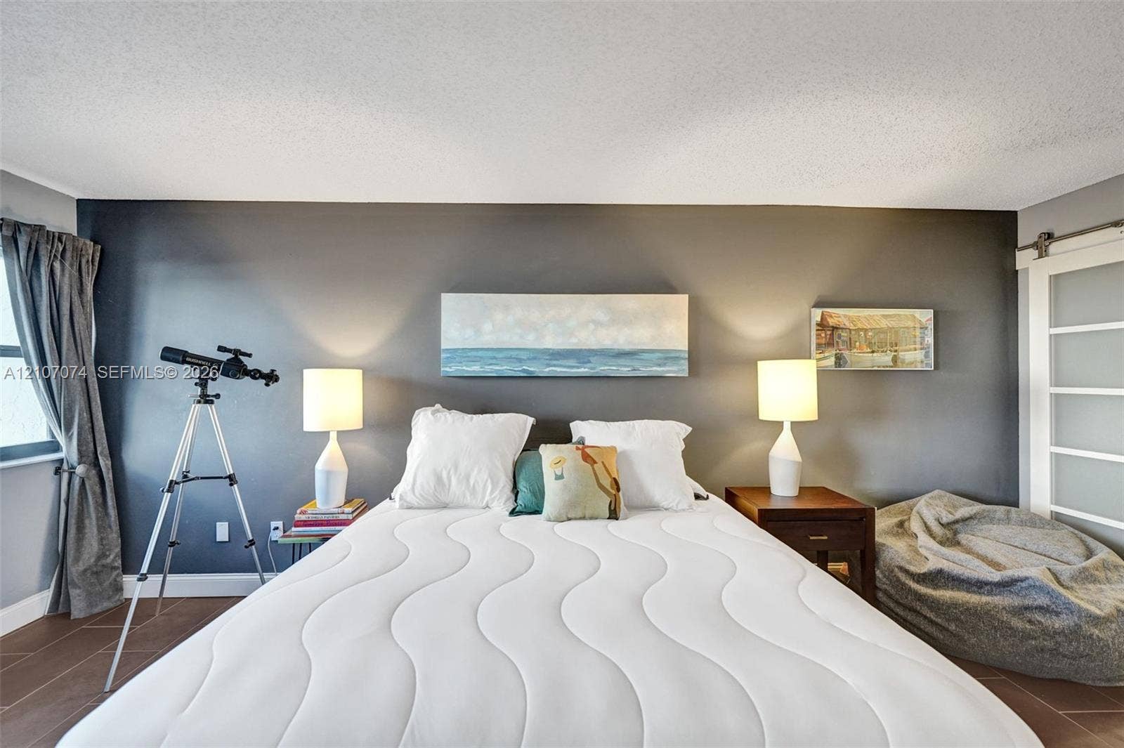 1201 S Ocean Drive, #218N, Hollywood, Hollywood, FL 33019 Room featuring charcoal-painted accent wall, large-format tile flooring, and sliding barn-style door with glass panels
