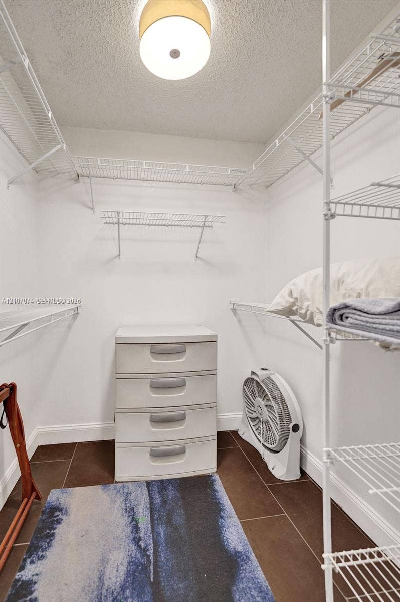 1201 S Ocean Drive, #218N, Hollywood, Hollywood, FL 33019 Storage area featuring white wire shelving, dark tile flooring, and a flush-mount overhead light fixture