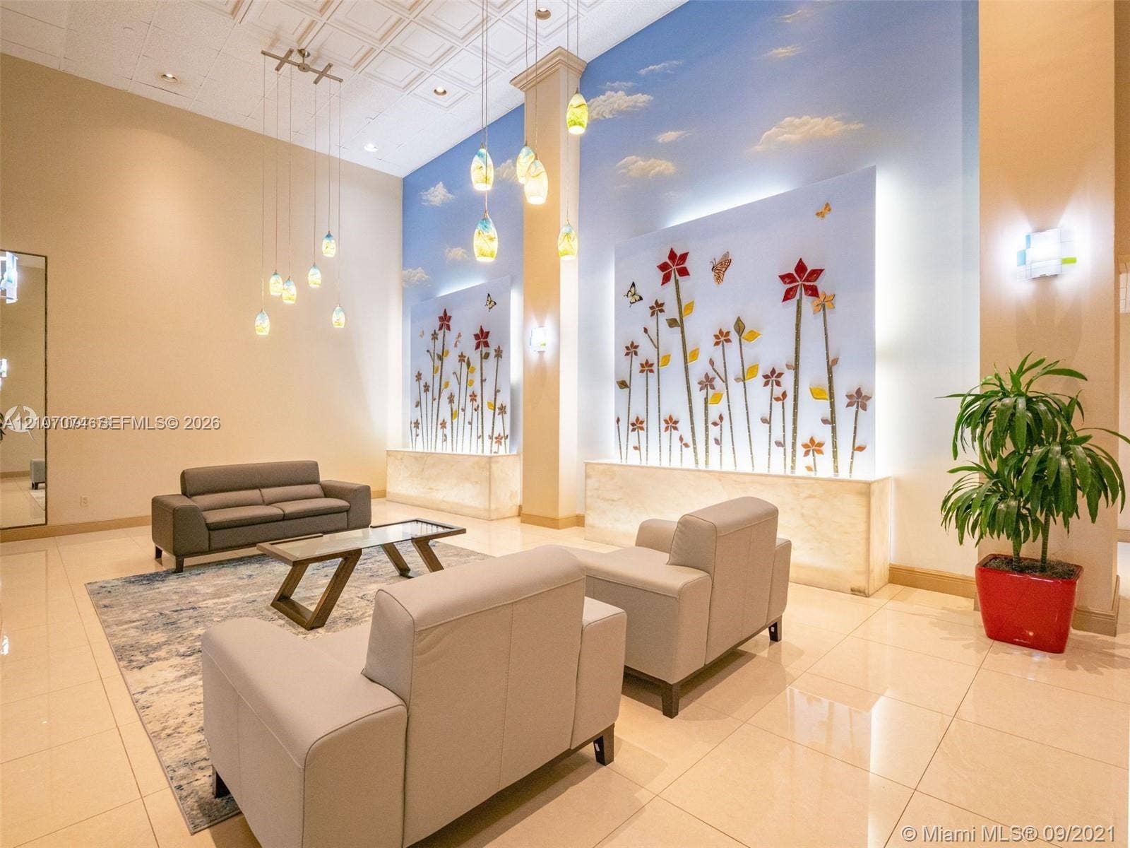 1201 S Ocean Drive, #218N, Hollywood, Hollywood, FL 33019 Double-height ceiling with coffered detailing, recessed wall art installations with integrated backlighting, multi-pendant light fixture, and polished tile flooring
