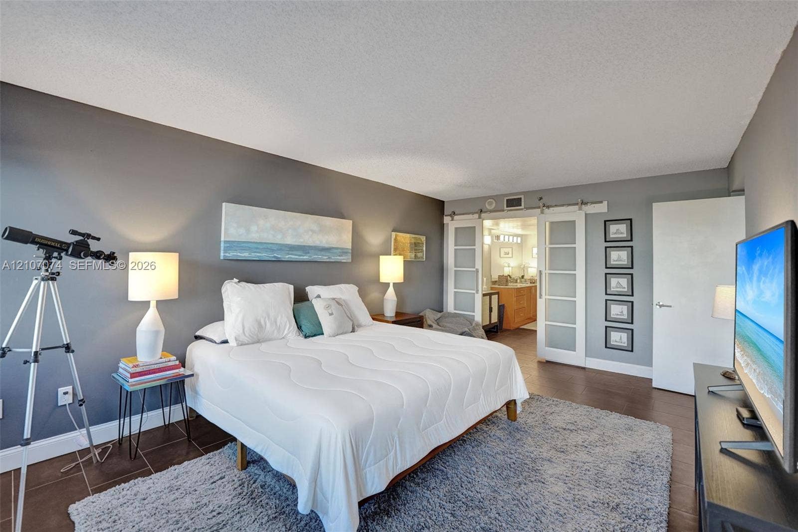 1201 S Ocean Drive, #218N, Hollywood, Hollywood, FL 33019 Spacious room featuring dark-toned walls, tile flooring, and dual glass-panel sliding barn doors with stainless steel hardware