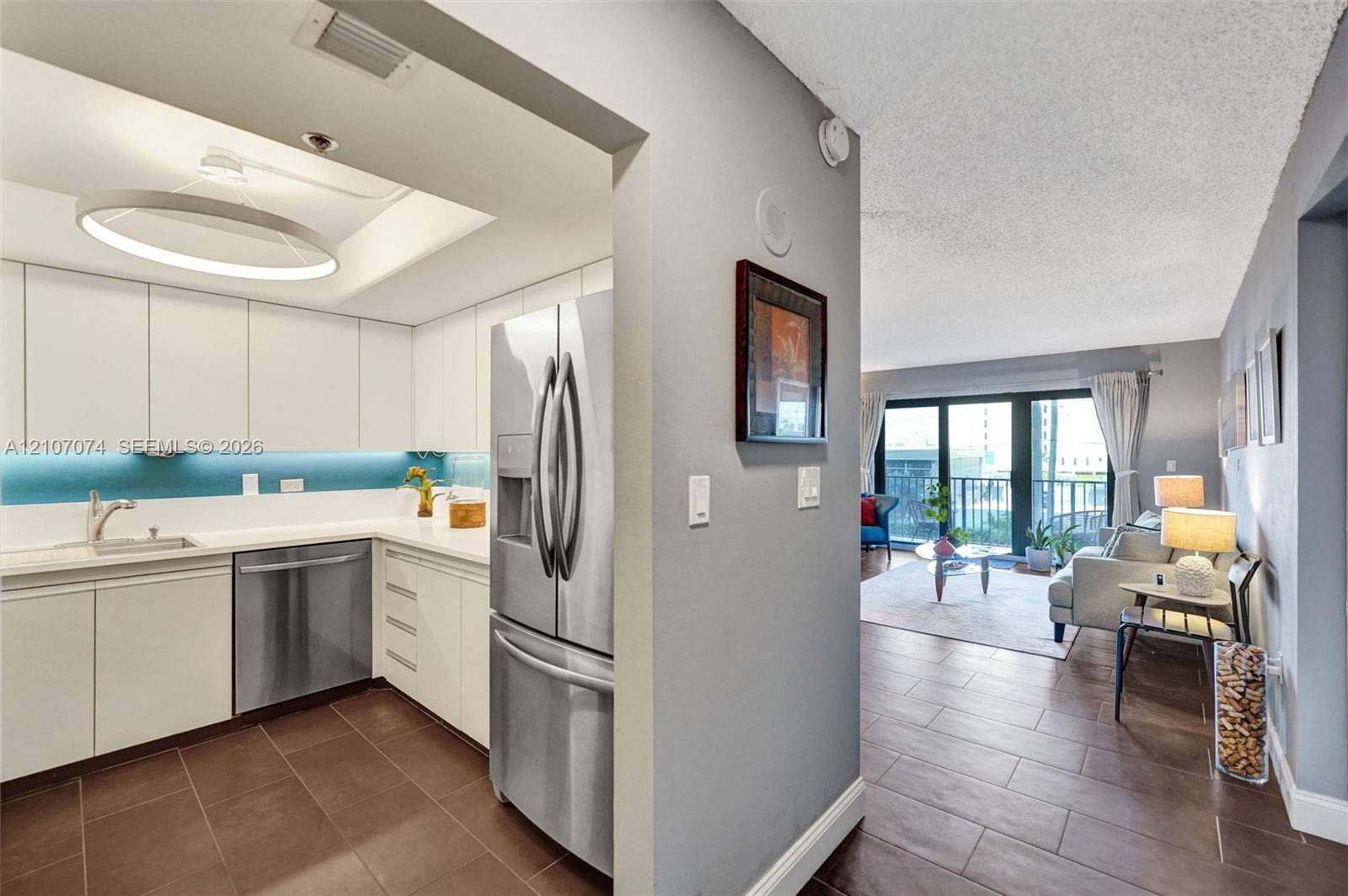 1201 S Ocean Drive, #218N, Hollywood, Hollywood, FL 33019 Kitchen featuring white flat-panel cabinetry, stainless steel refrigerator and dishwasher, recessed ceiling lighting, circular pendant fixture, and large-format tile flooring