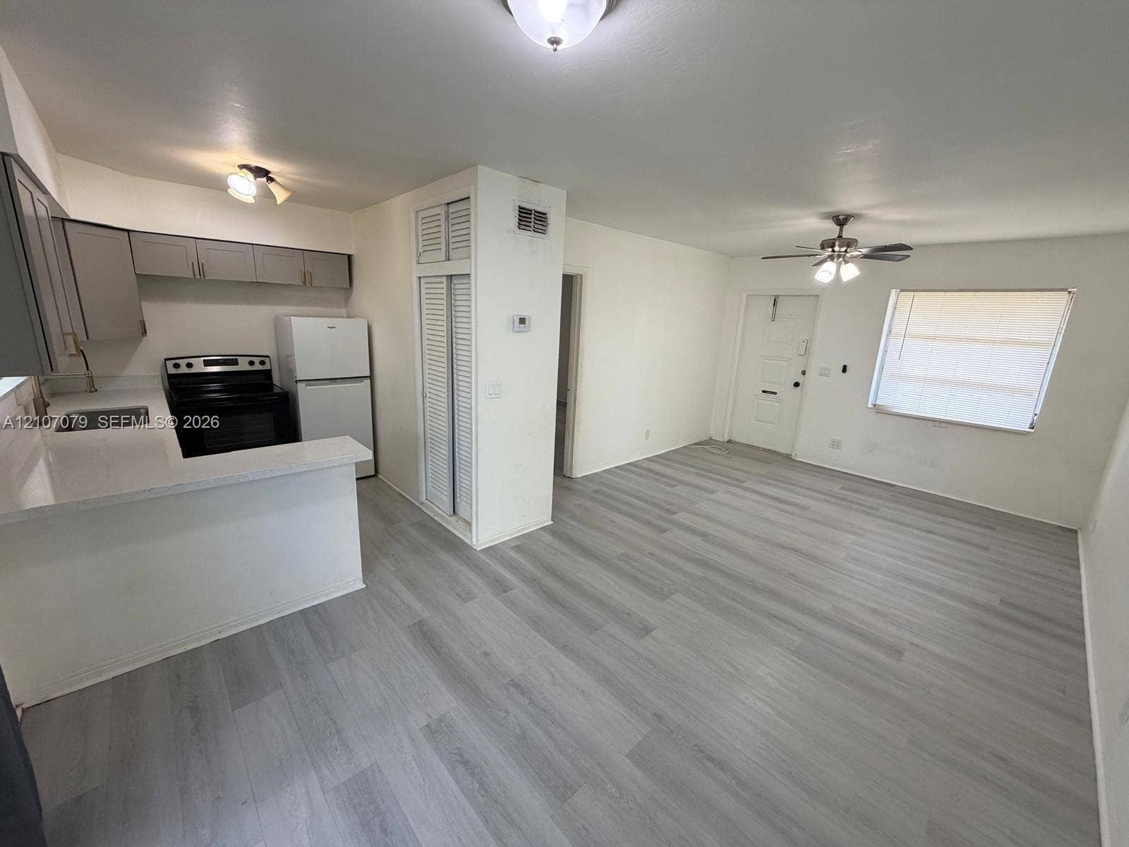 2450 Lincoln Street, #3, Hollywood, Hollywood, FL 33020 Kitchen featuring gray cabinetry, solid surface countertops, wood-finish flooring, and a ceiling fan with integrated lighting