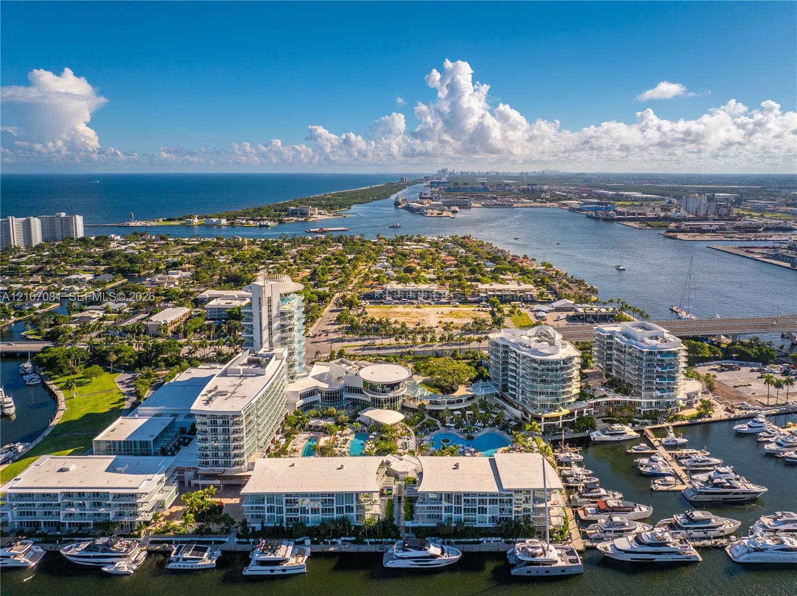 Waterfront complex featuring high-rise buildings, an integrated marina, multiple swimming pools, and extensive coastal landscape