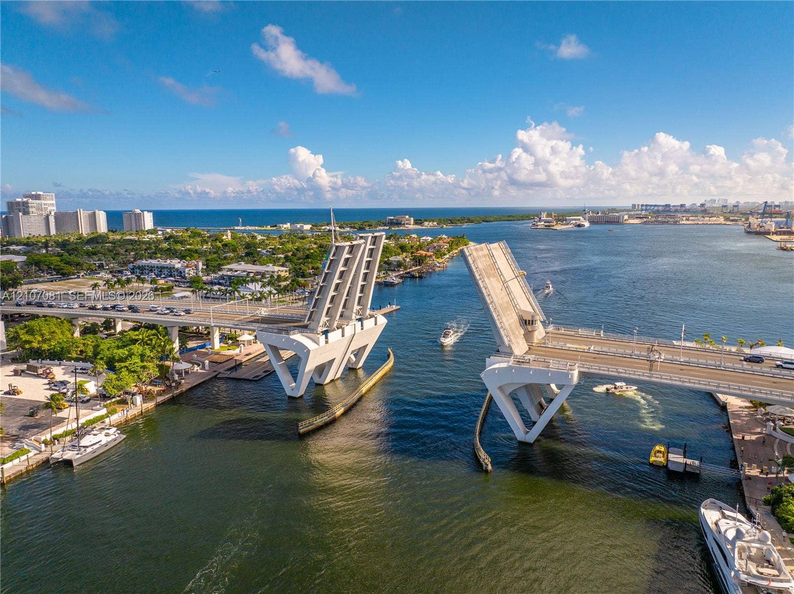 Aerial perspective of a coastal inlet featuring a drawbridge, deep-water access, and boat docking facilities