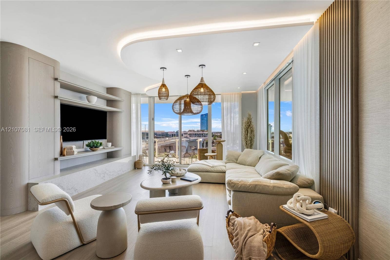 Curved ceiling detail with integrated perimeter lighting, floor-to-ceiling windows, custom built-in cabinetry with shelving, stone-finish media hearth, and vertical wood-slat wall paneling