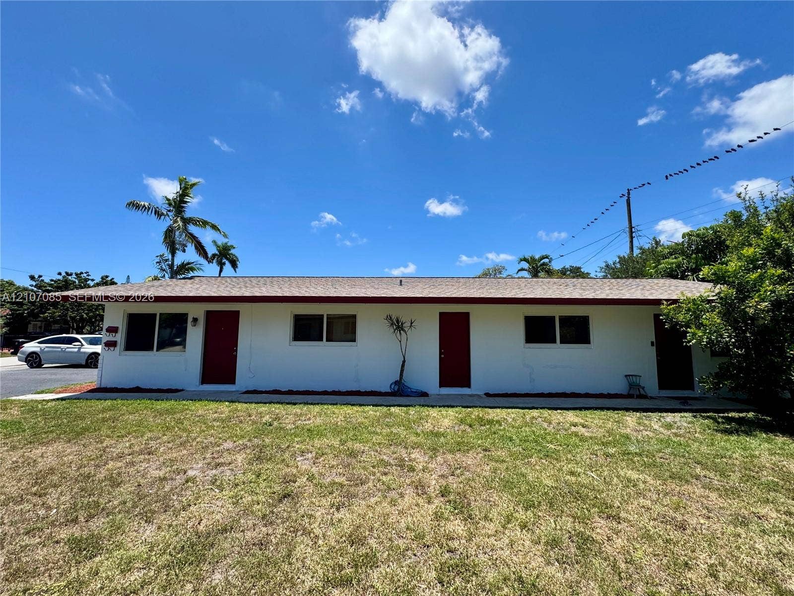 2641 SW 13th Avenue, #1, Fort Lauderdale, Fort Lauderdale, FL 33315 Single-story exterior featuring white stucco siding, a low-slope roof, and multiple entry doors with dark-tone trim