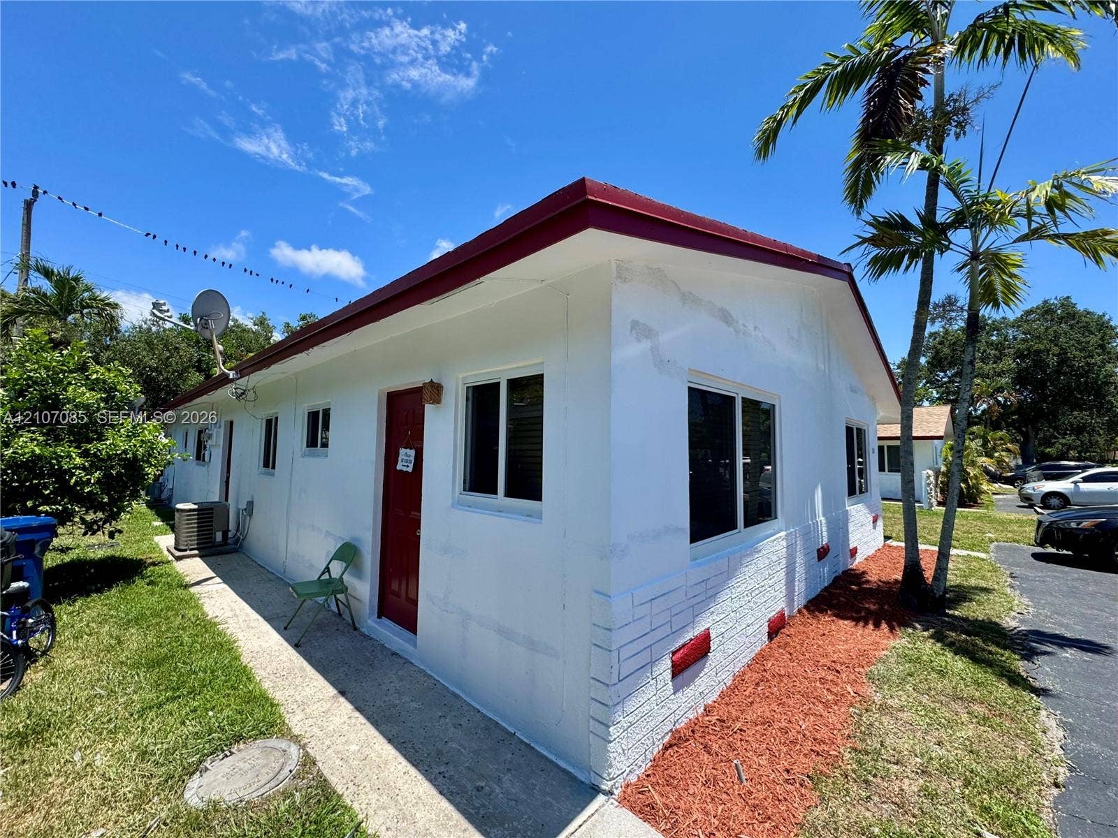 2641 SW 13th Avenue, #1, Fort Lauderdale, Fort Lauderdale, FL 33315 Exterior featuring a painted masonry facade, metal roof, concrete walkway, and landscaped mulch beds