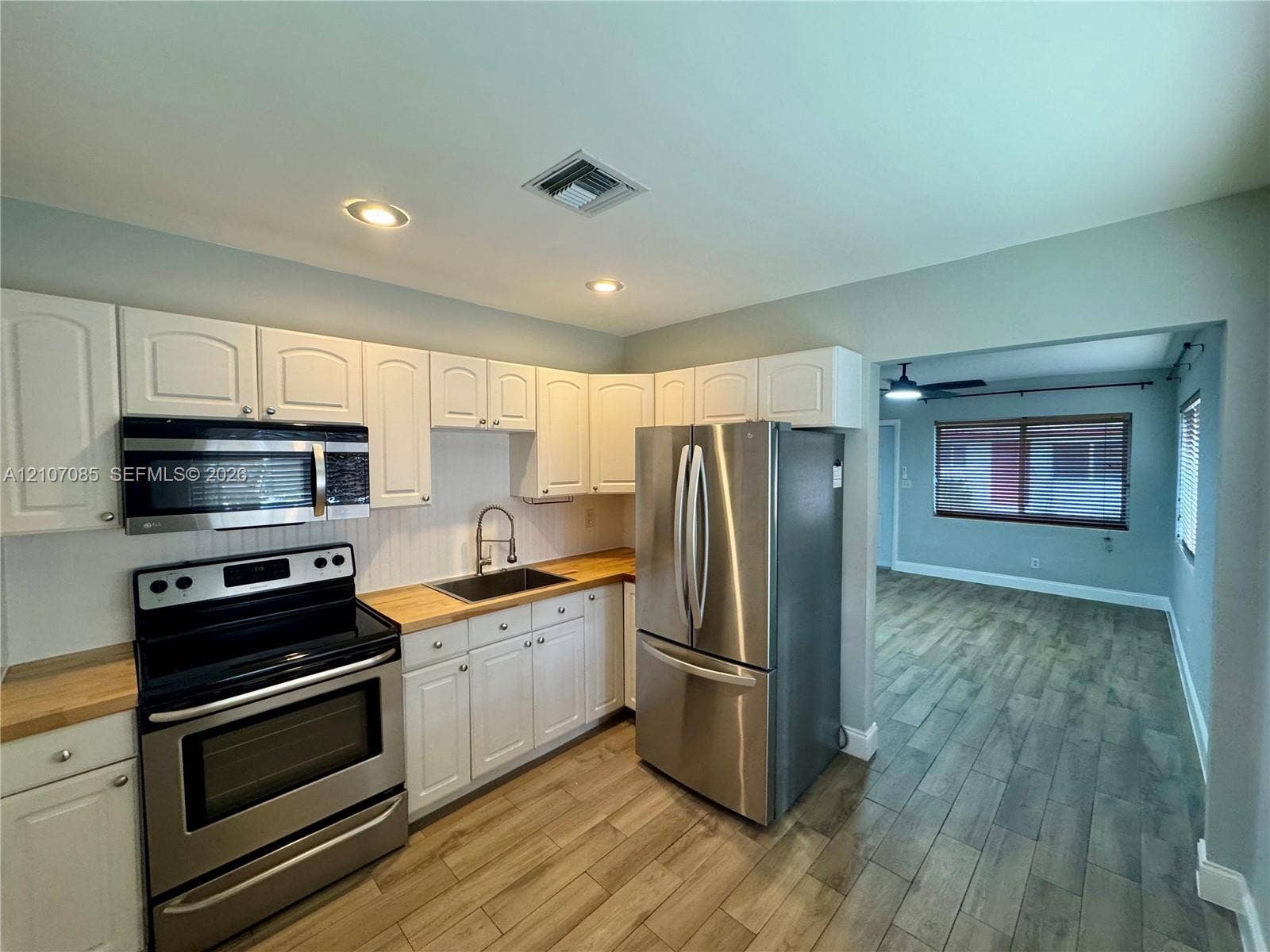 2641 SW 13th Avenue, #1, Fort Lauderdale, Fort Lauderdale, FL 33315 Kitchen featuring white cabinetry, wood-finish countertops, stainless steel appliances, and recessed lighting with wood-finish flooring extending into the interior space