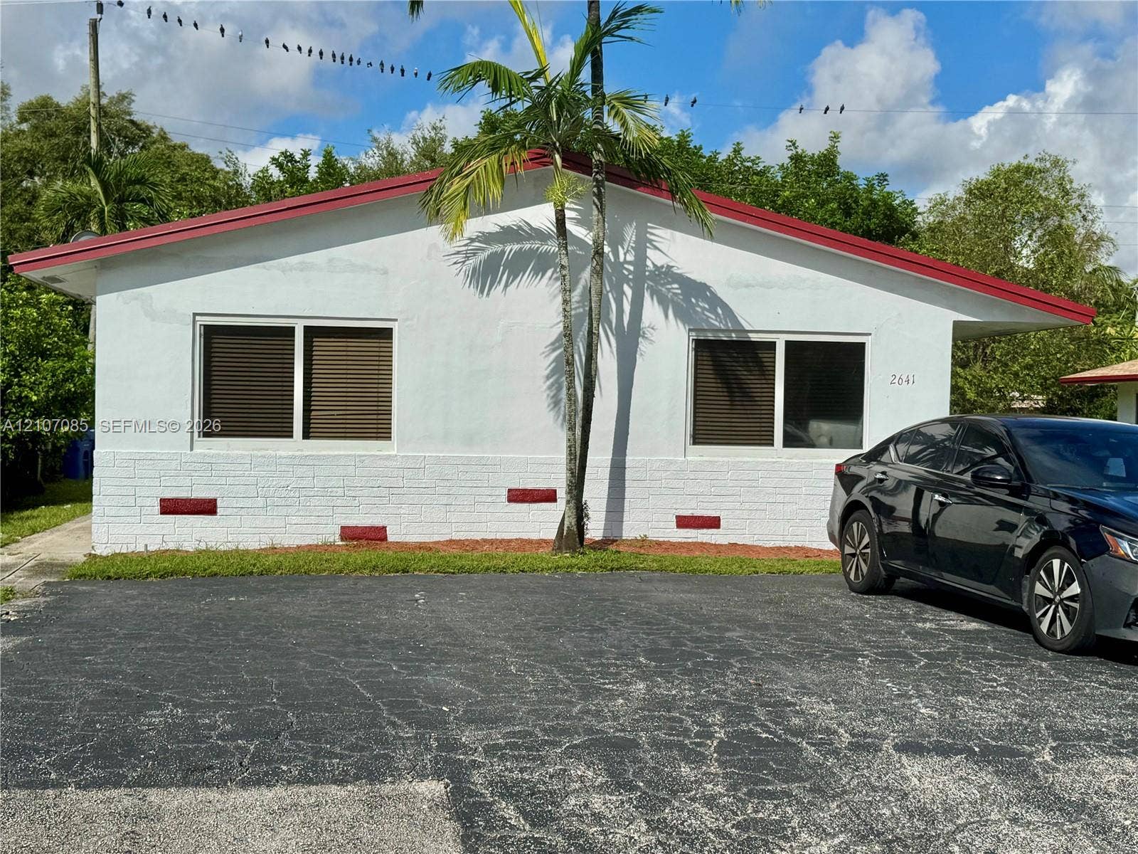 2641 SW 13th Avenue, #1, Fort Lauderdale, Fort Lauderdale, FL 33315 Exterior featuring a white facade with textured masonry base, red roofline accents, and dual sliding windows