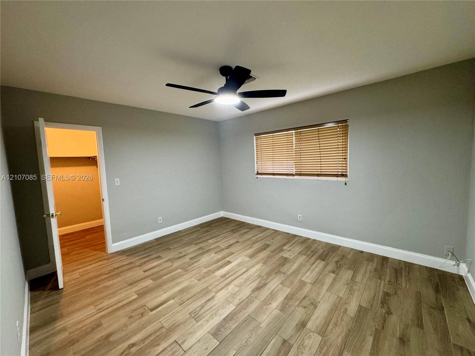 2641 SW 13th Avenue, #1, Fort Lauderdale, Fort Lauderdale, FL 33315 Neutral-toned interior room featuring wood-finish flooring, a ceiling fan with integrated lighting, and horizontal window blinds