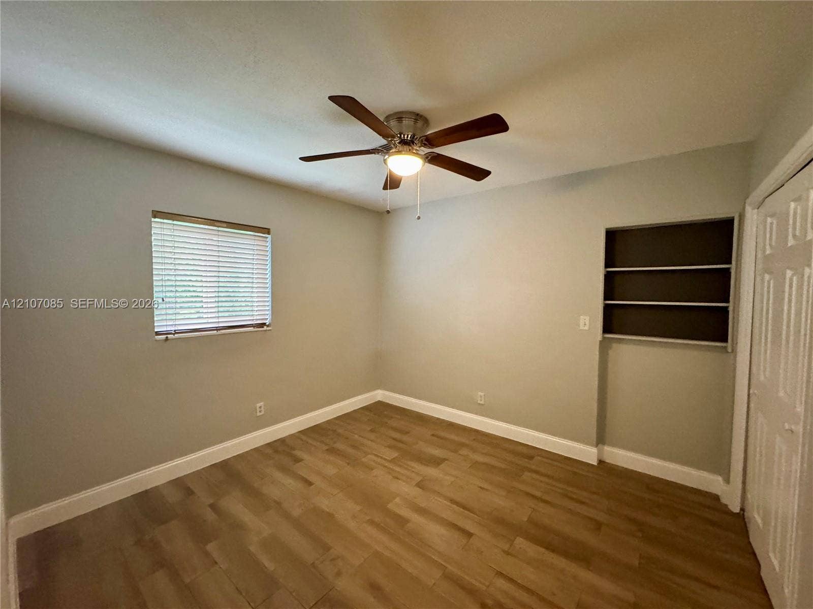 2641 SW 13th Avenue, #1, Fort Lauderdale, Fort Lauderdale, FL 33315 Wood-finish flooring, ceiling fan with integrated lighting, built-in wall shelving, and window with horizontal blinds