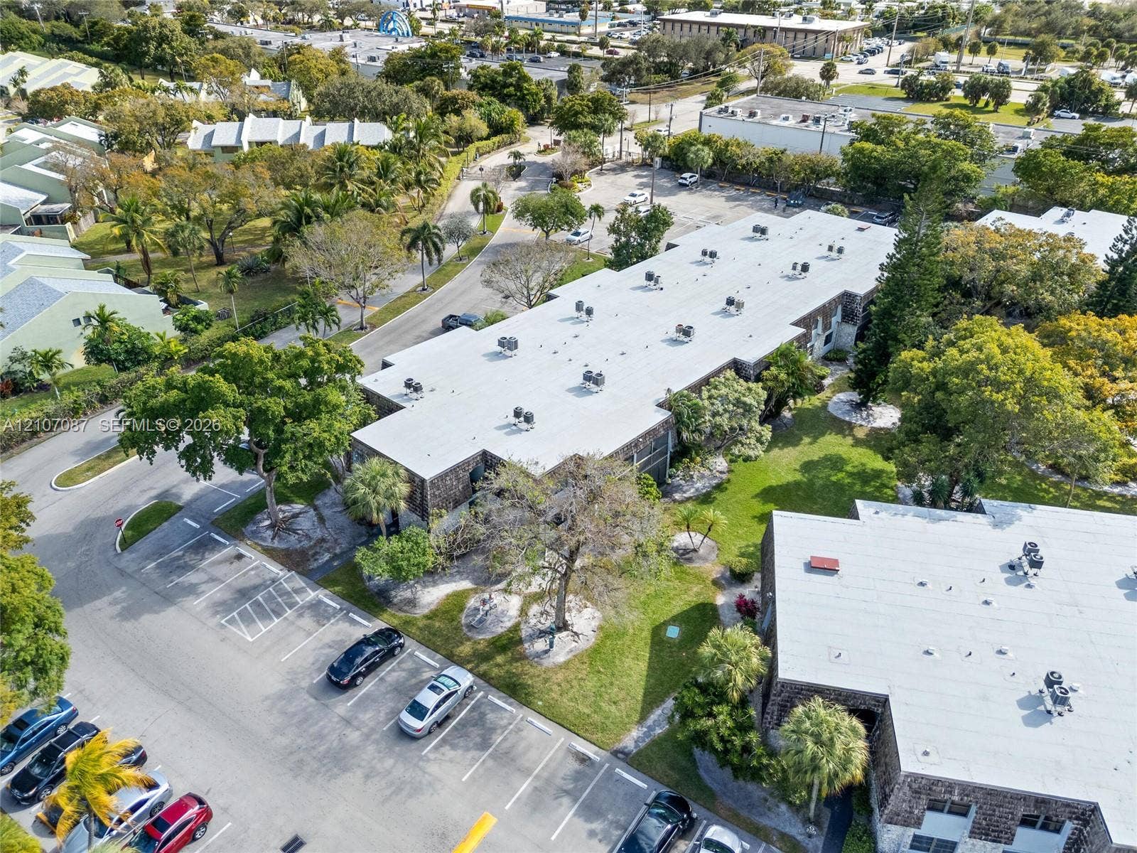 Multi-level commercial structure featuring a flat roofline, stone veneer exterior, and dedicated surface parking
