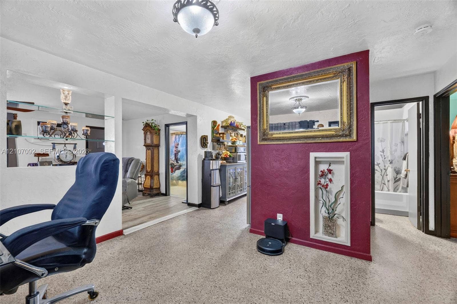 2864 NE 12th Terrace, Pompano Beach, FL 33064 Interior space featuring terrazzo flooring, a built-in recessed wall niche, a decorative accent wall, and glass display shelving