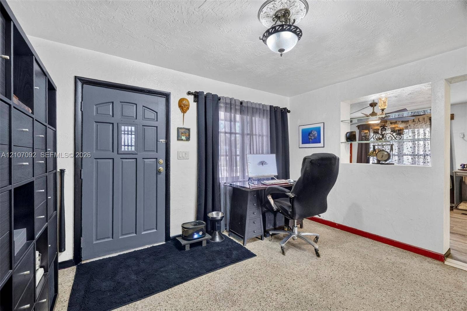 2864 NE 12th Terrace, Pompano Beach, FL 33064 Entryway featuring a multi-panel door with inset glass, decorative ceiling medallion with pendant lighting, and a recessed wall niche with glass shelving
