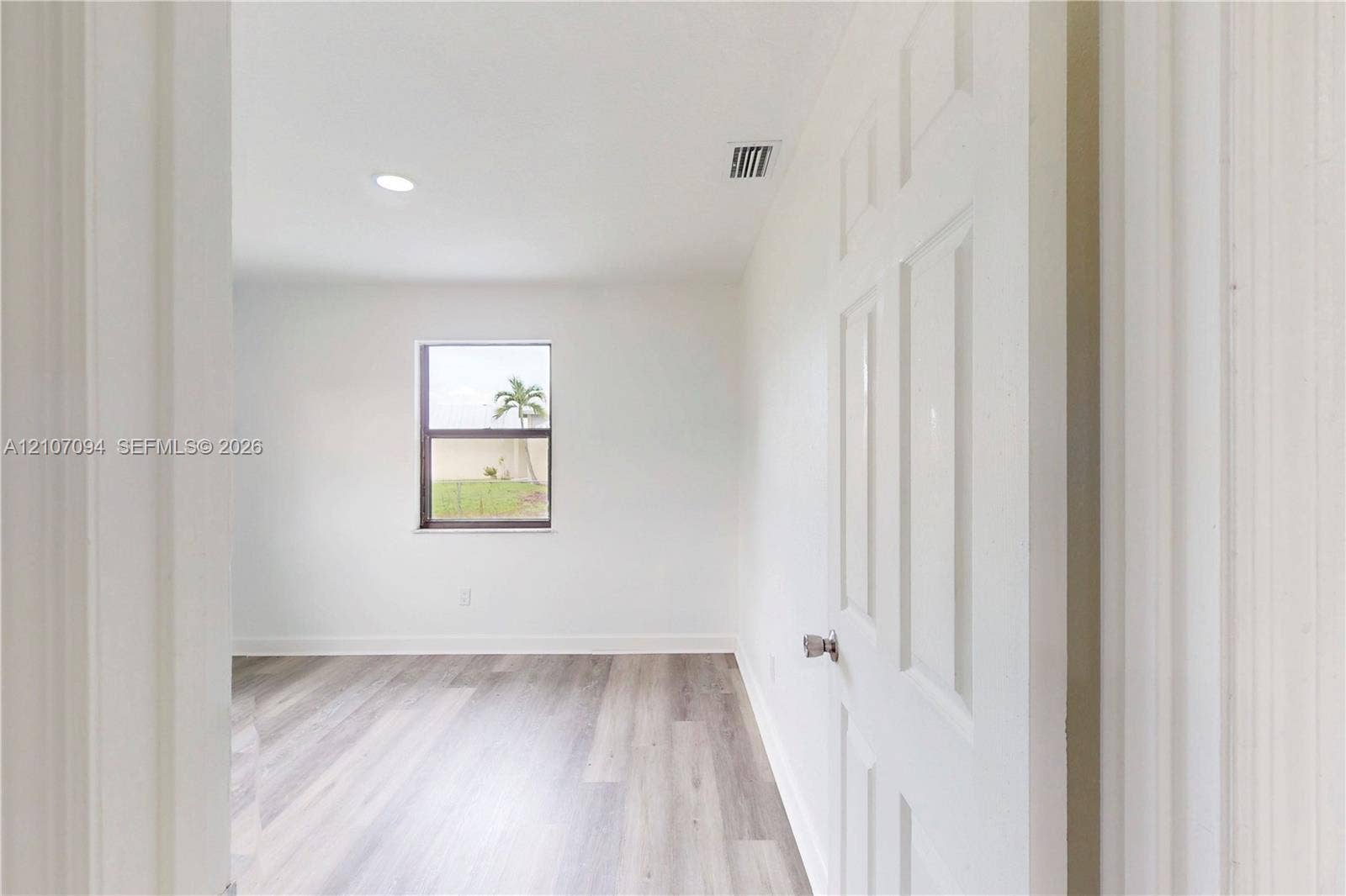 1131 SW London Lane, Port St Lucie, FL 34953 Interior room featuring wood-finish flooring, recessed lighting, and a single-panel window