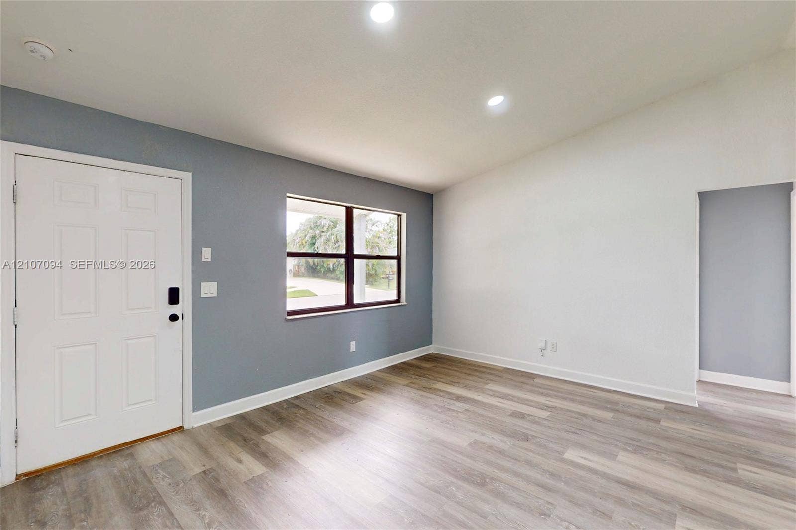 1131 SW London Lane, Port St Lucie, FL 34953 Vaulted ceilings, wood-finish flooring, recessed lighting, and a multi-pane window