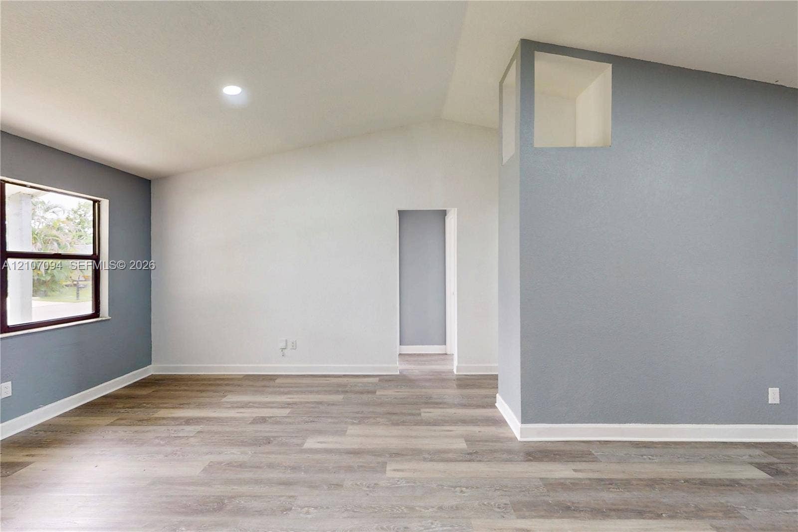 1131 SW London Lane, Port St Lucie, FL 34953 Vaulted ceilings, wood-finish flooring, recessed lighting, and a prominent architectural niche