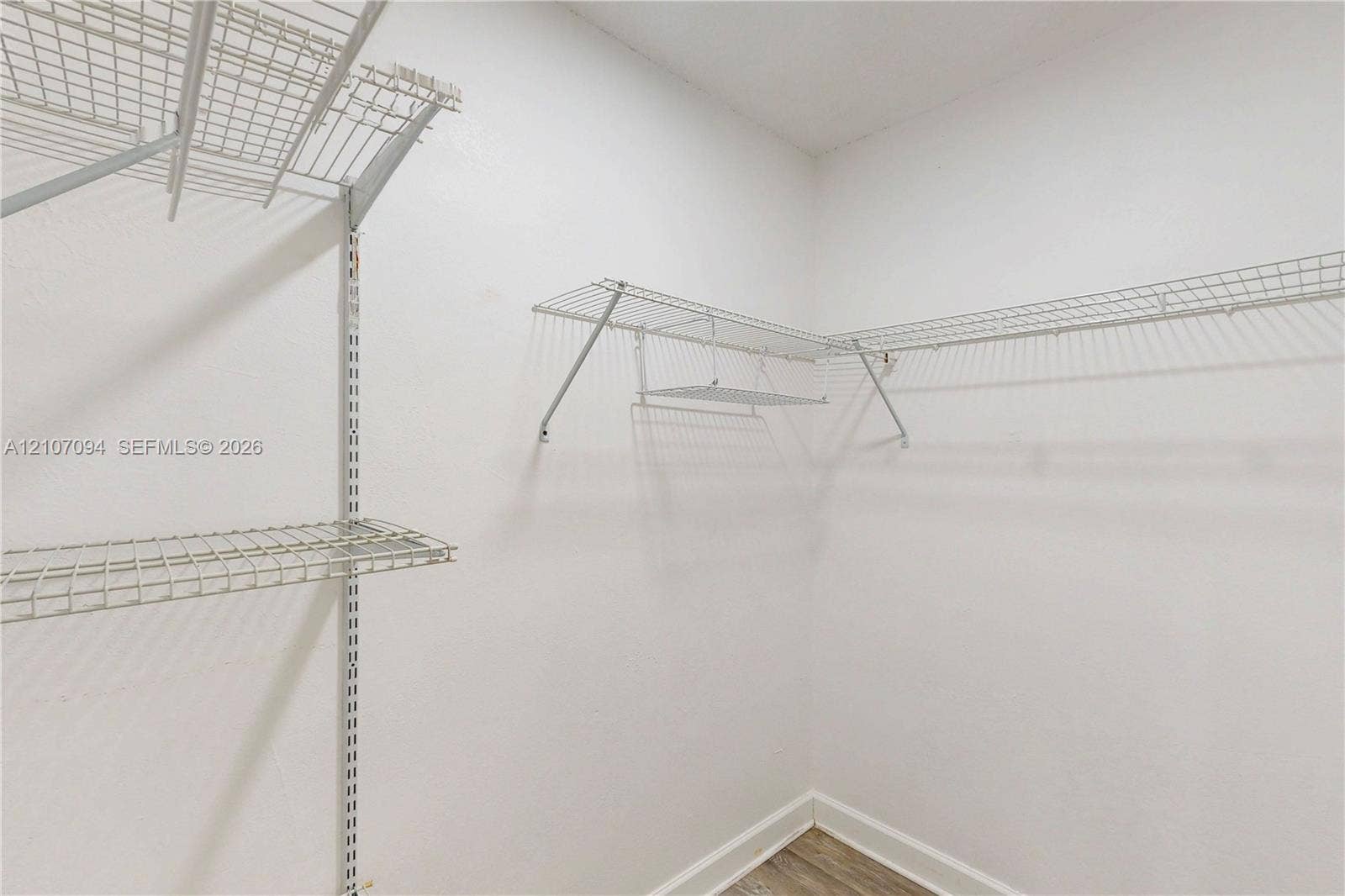 1131 SW London Lane, Port St Lucie, FL 34953 Storage area featuring wall-mounted wire shelving and wood-finish flooring