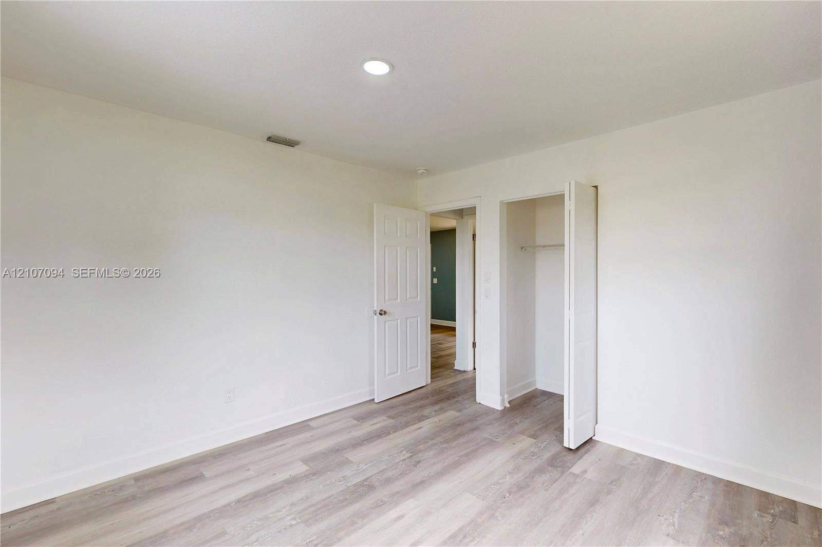 1131 SW London Lane, Port St Lucie, FL 34953 Room featuring wood-finish flooring, recessed lighting, and a closet with bifold doors