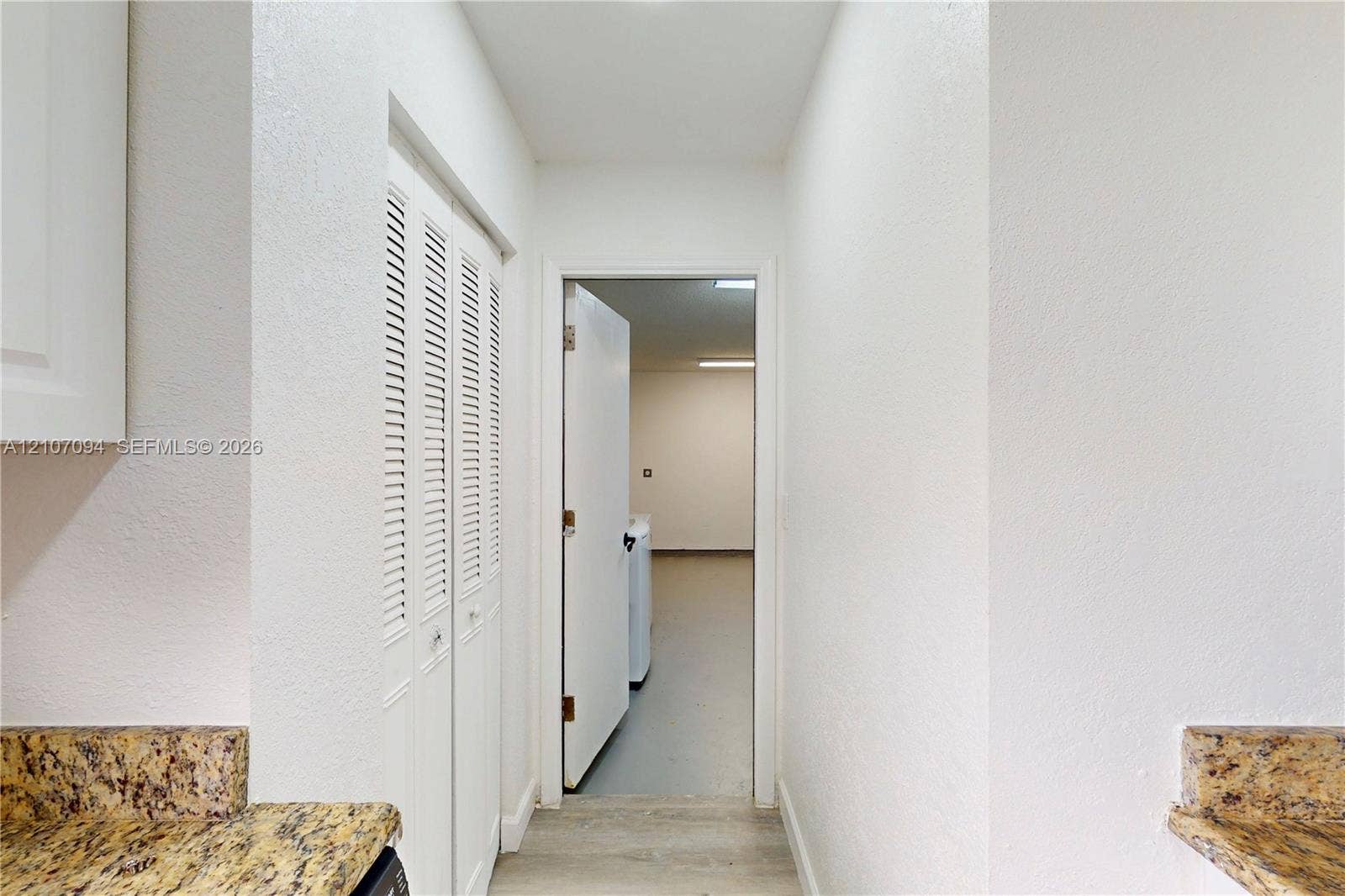 1131 SW London Lane, Port St Lucie, FL 34953 Textured stone-finish countertops, white louvered-door closet, and neutral wood-finish flooring