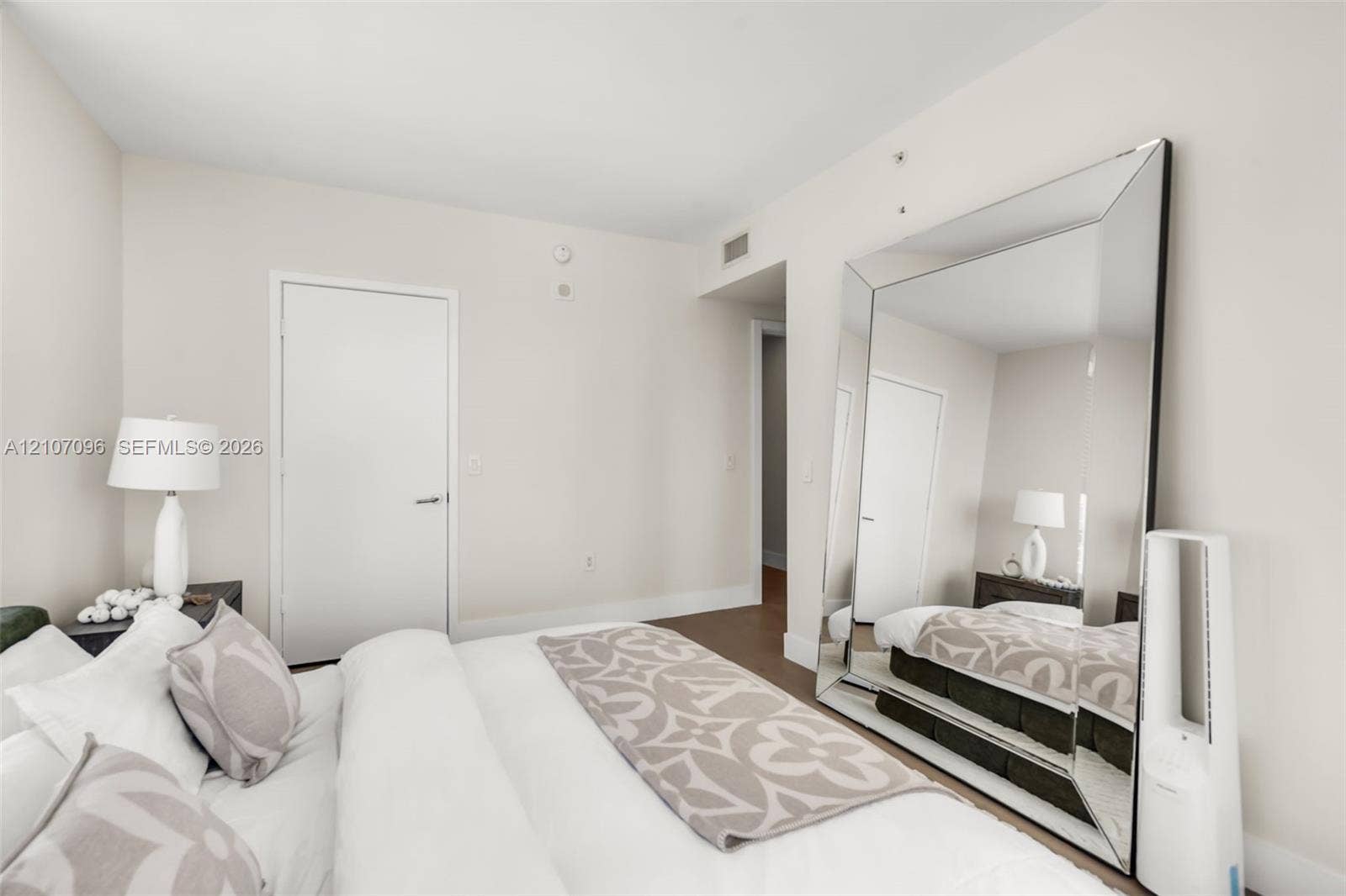 Neutral-toned interior space featuring wood-finish flooring and solid-core interior doors