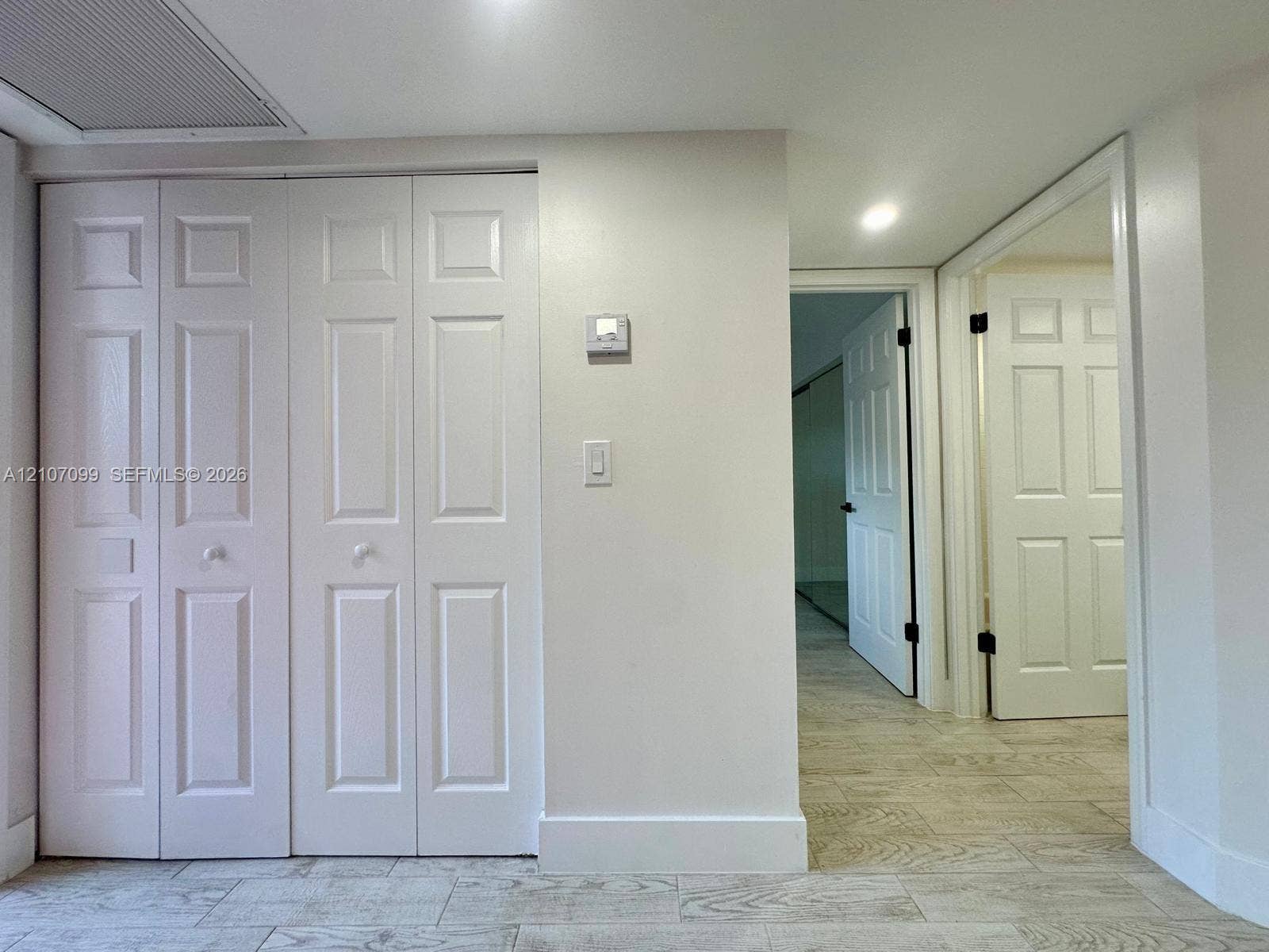 Bi-fold closet doors, six-panel interior doors, and tile flooring