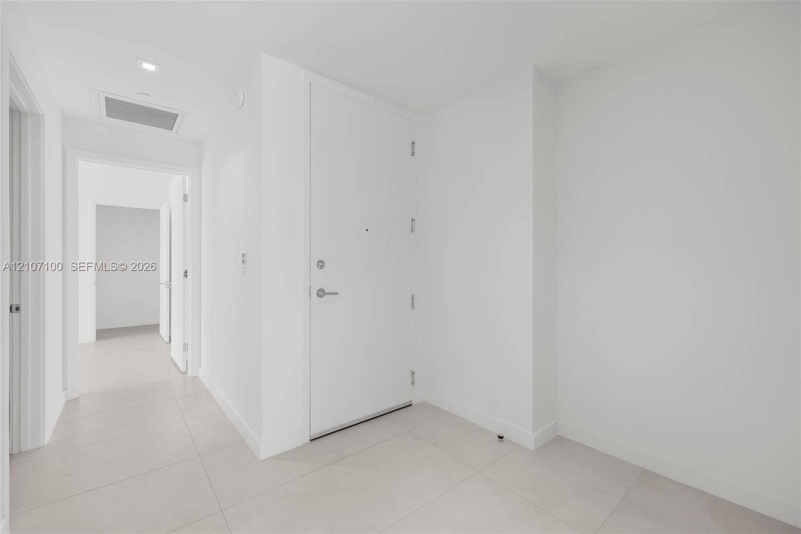 Entryway featuring large-format ceramic floor tiling, smooth-finish walls, and a recessed ceiling light fixture
