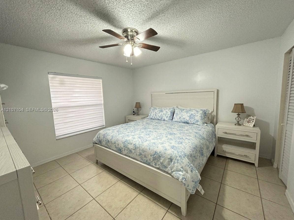 16259 SW 306th Street, #0, Homestead, Homestead, FL 33033 Neutral-toned ceramic tile flooring, ceiling fan with integrated light fixture, window with horizontal blinds, and louvered closet doors