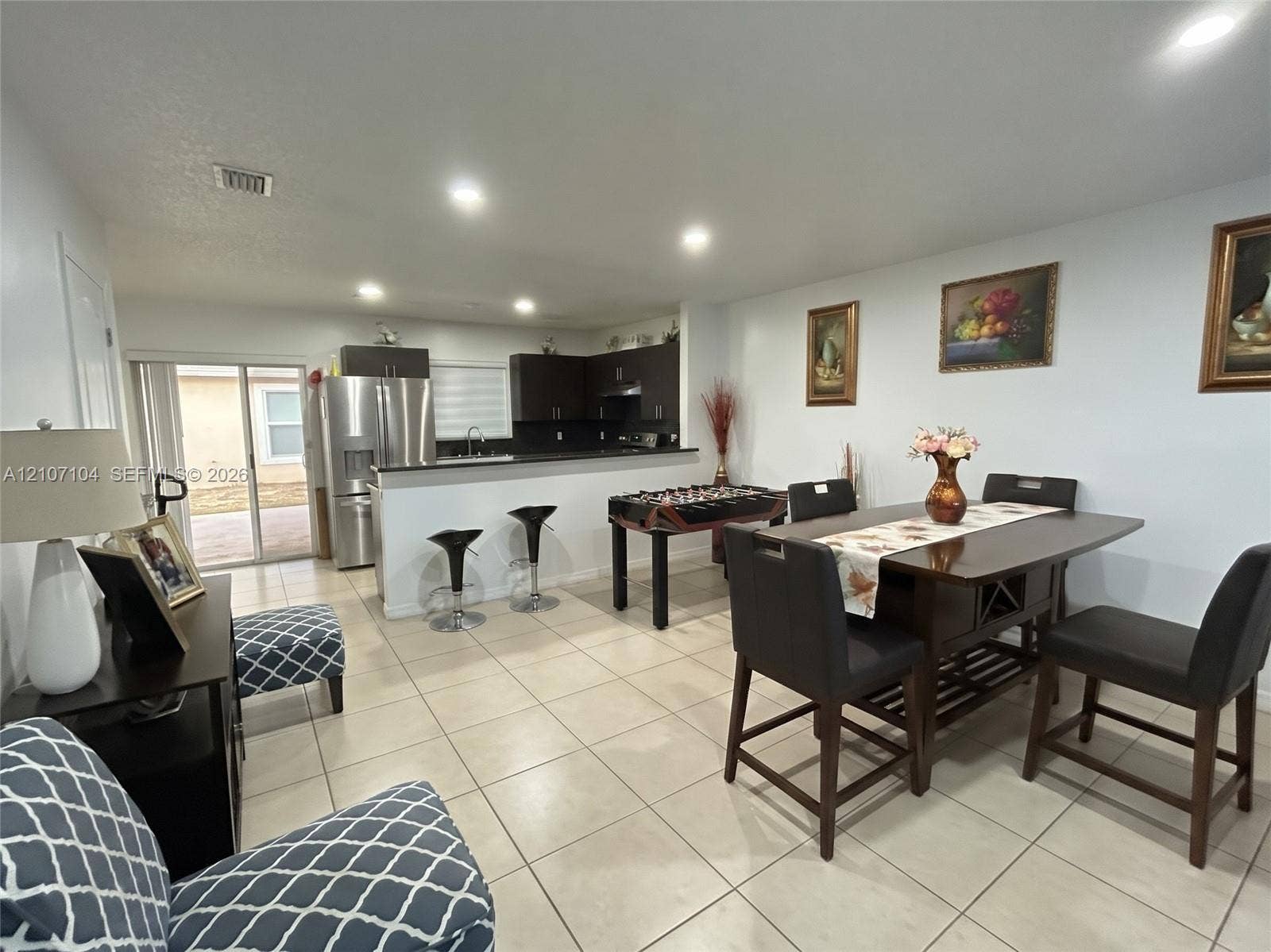 16259 SW 306th Street, #0, Homestead, Homestead, FL 33033 Open-concept area featuring ceramic tile flooring, recessed lighting, and a kitchen with dark cabinetry, stone-surface countertops, and a breakfast bar