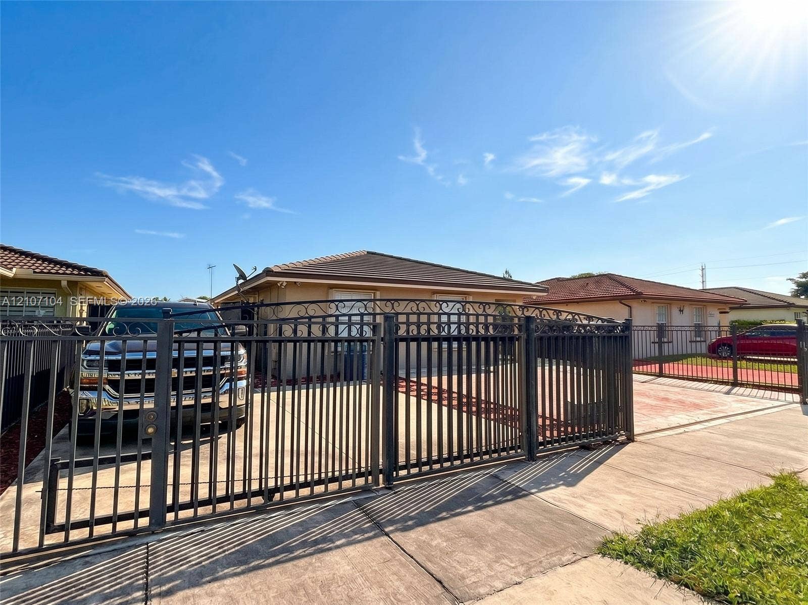 16259 SW 306th Street, #0, Homestead, Homestead, FL 33033 Single-story residence featuring a decorative metal perimeter fence with an arched gate, paved driveway, and low-slope roof