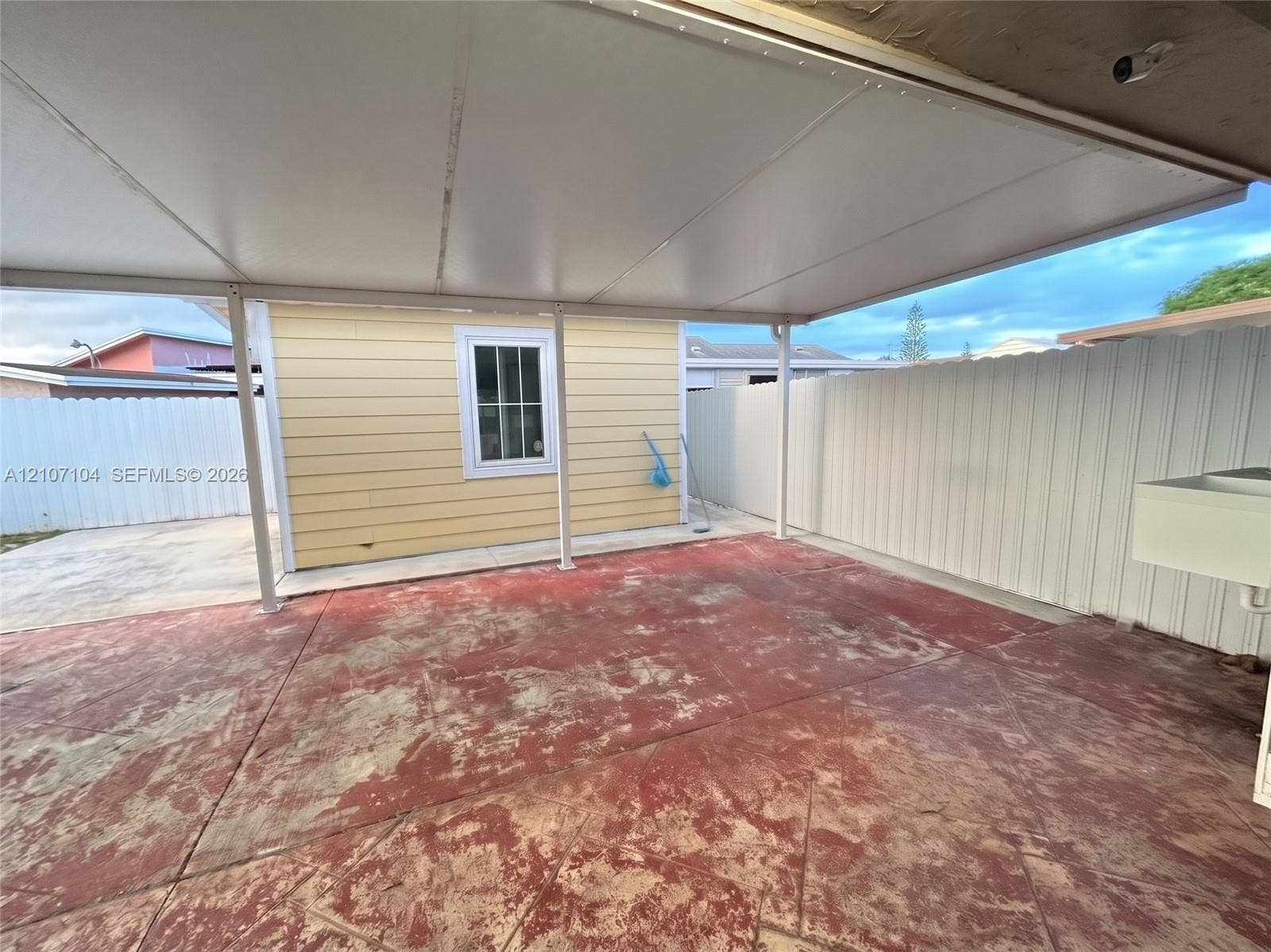 16259 SW 306th Street, #0, Homestead, Homestead, FL 33033 Covered outdoor patio featuring a concrete floor, horizontal siding, a multi-pane window, and a white privacy fence