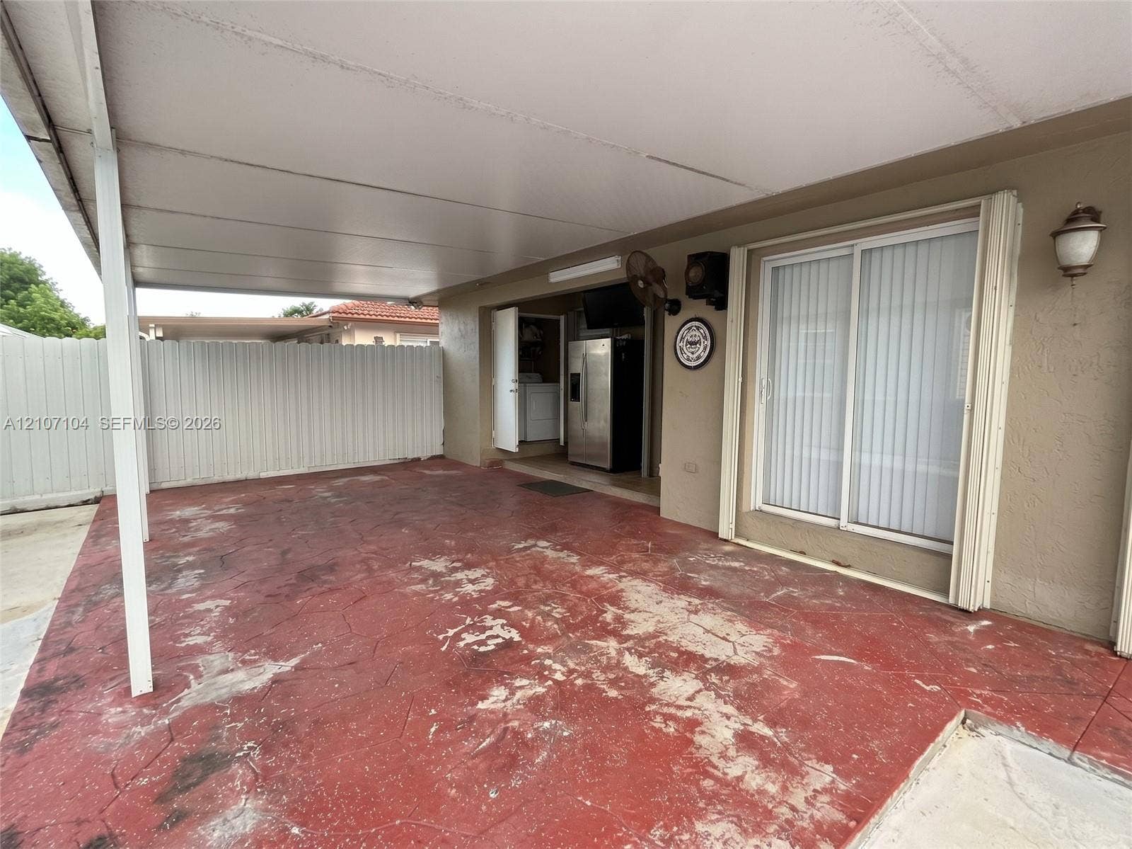 16259 SW 306th Street, #0, Homestead, Homestead, FL 33033 Covered patio featuring a stained concrete floor, sliding glass doors, and white vinyl perimeter fencing