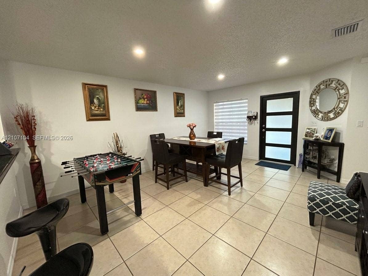 16259 SW 306th Street, #0, Homestead, Homestead, FL 33033 Neutral-toned tile flooring, recessed ceiling lighting, and a modern entry door featuring four horizontal frosted glass panels