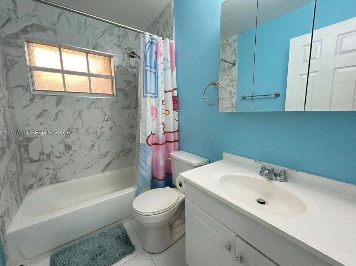 16259 SW 306th Street, #0, Homestead, Homestead, FL 33033 Bathroom featuring a tub-and-shower combination with patterned wall tile surround, a built-in recessed medicine cabinet, a single-basin vanity with solid-surface countertop, and an integrated horizontal window
