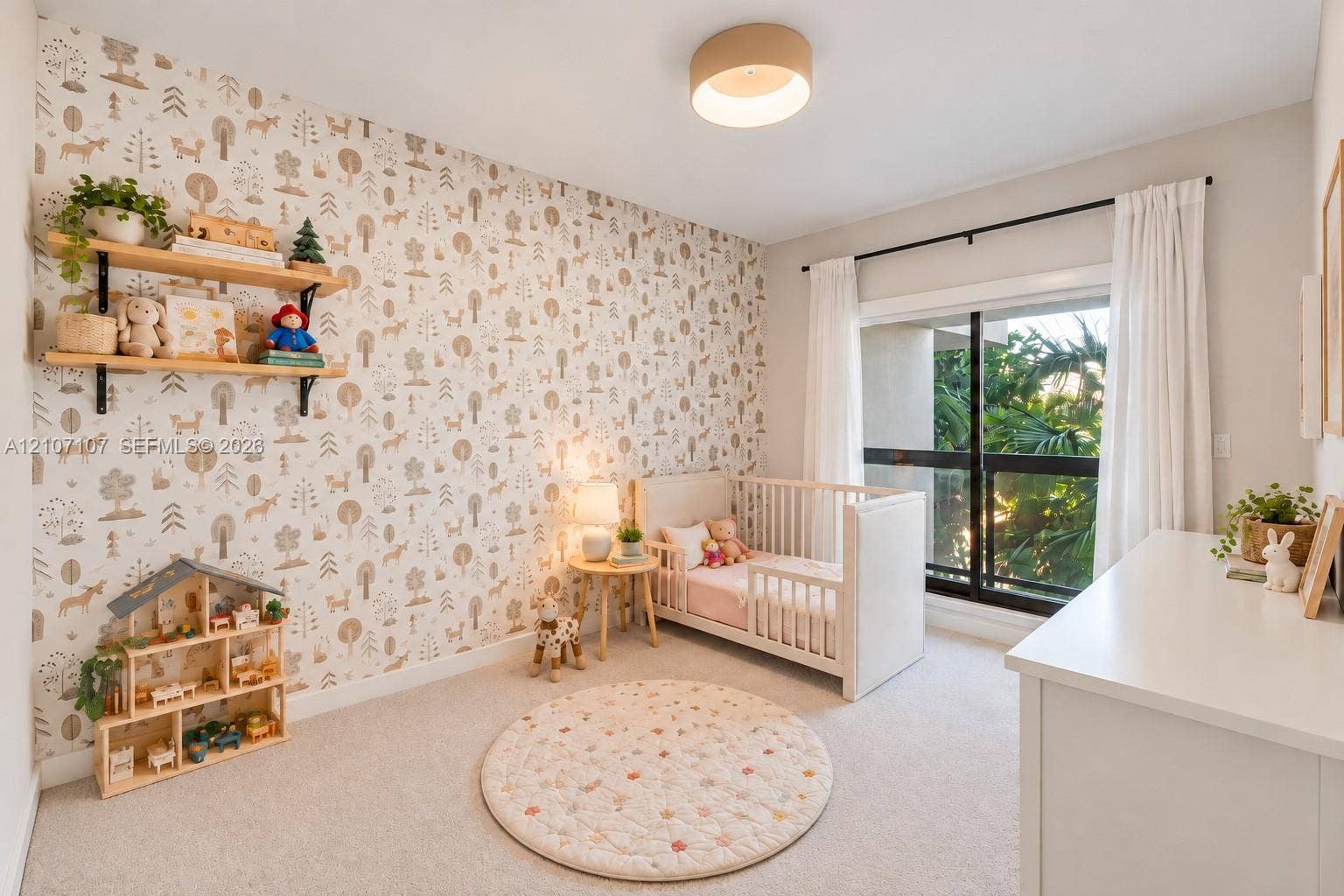 Room with patterned wallpaper, wall-mounted shelving, neutral carpeting, and a sliding glass door with a black frame