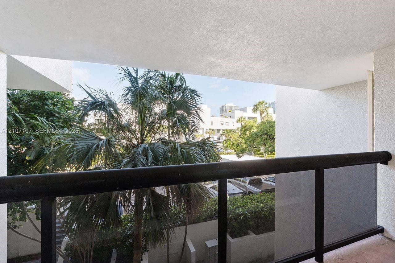 Covered balcony featuring a black metal railing and a textured stucco ceiling
