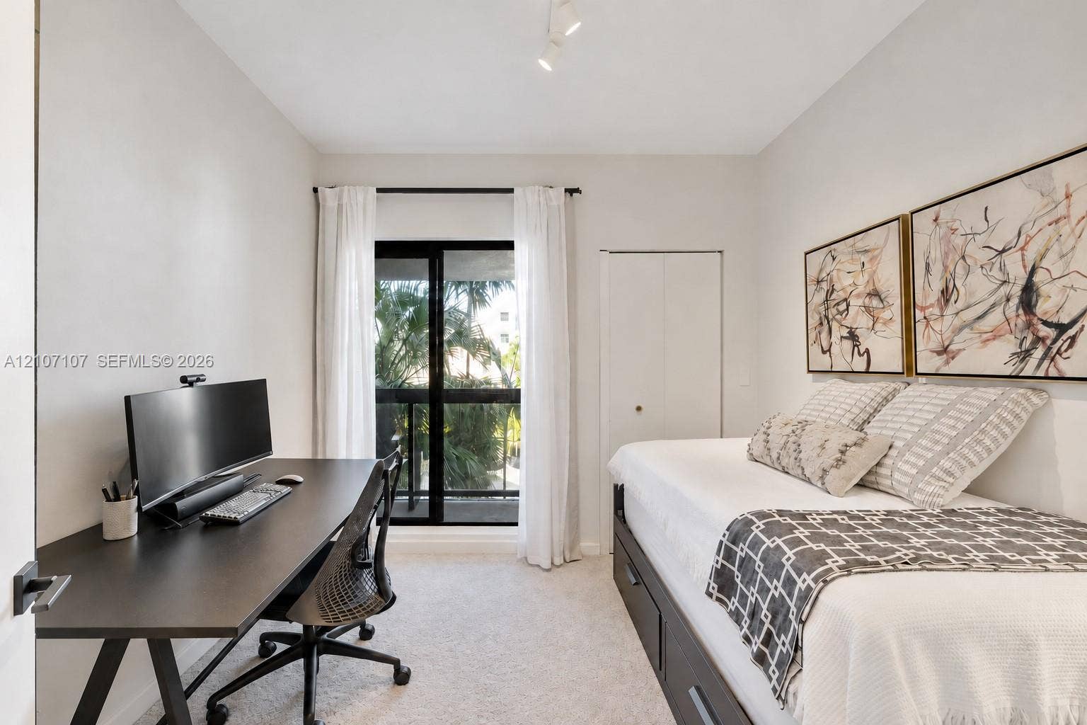 Neutral-toned room featuring wall-to-wall carpeting, sliding glass doors providing outdoor access, and a closet with dual-panel doors