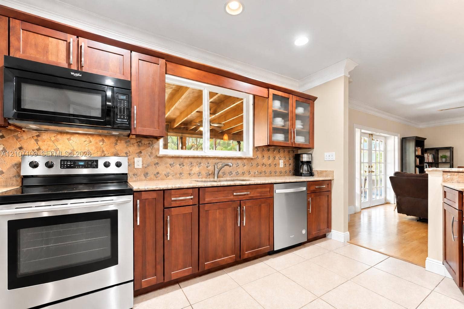 Kitchen featuring shaker-style wood cabinetry, stainless steel appliances, a decorative tile backsplash, stone-finish countertops, and recessed lighting