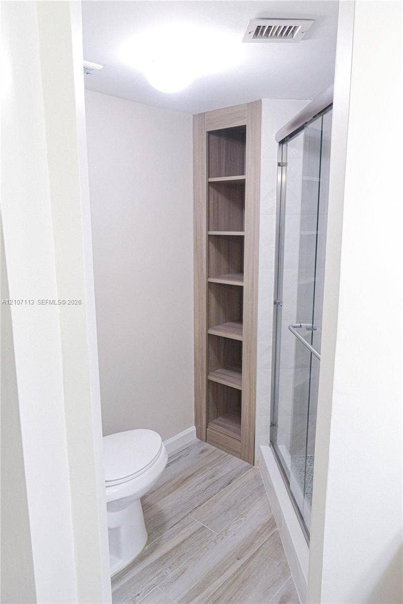 10451 W Broward Boulevard, #102, Plantation, Plantation, FL 33324 Built-in wood-finish shelving, walk-in shower with glass enclosure, and wood-finish flooring
