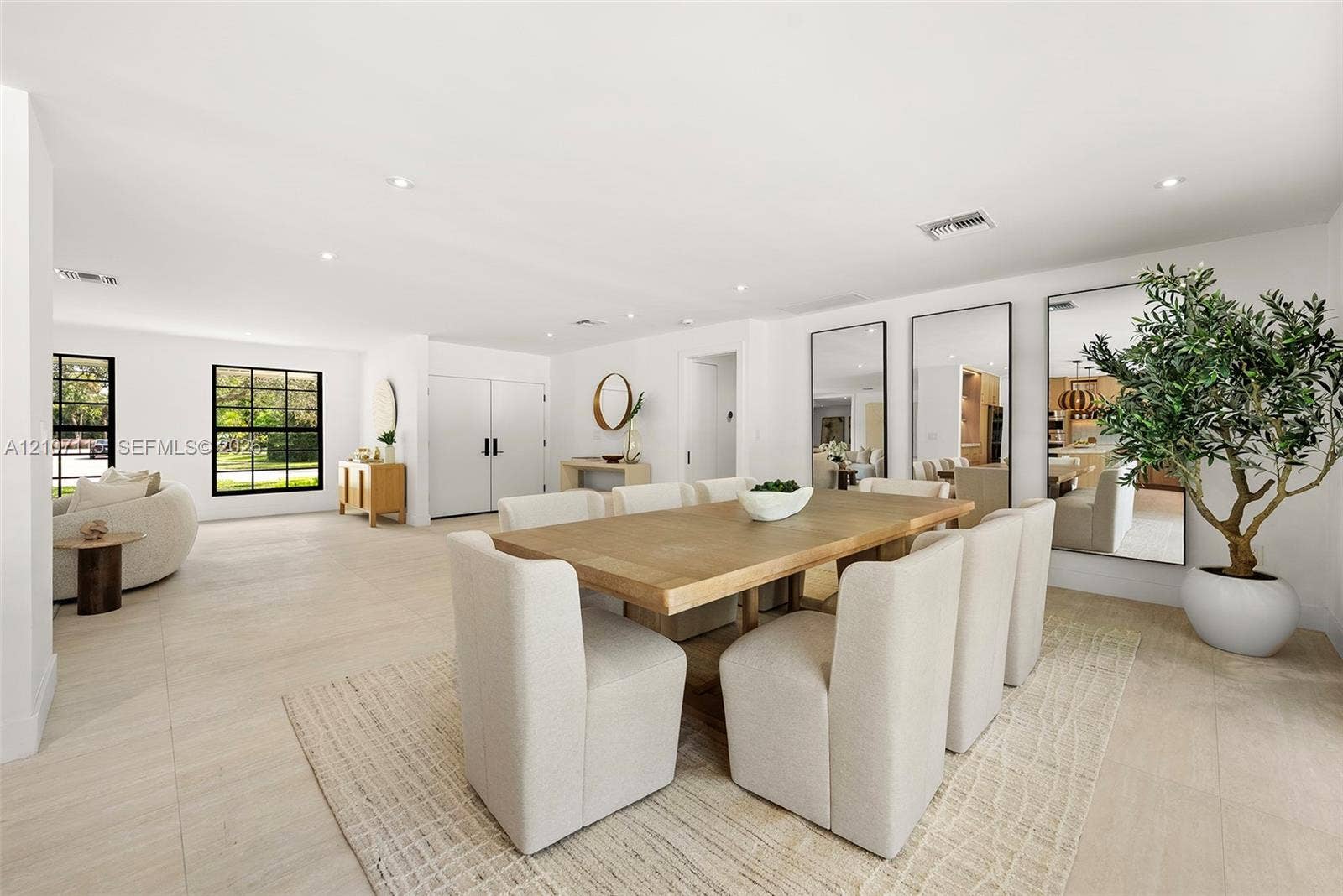 Open-concept room featuring light-toned tile flooring, recessed ceiling lighting, and large, black-framed windows