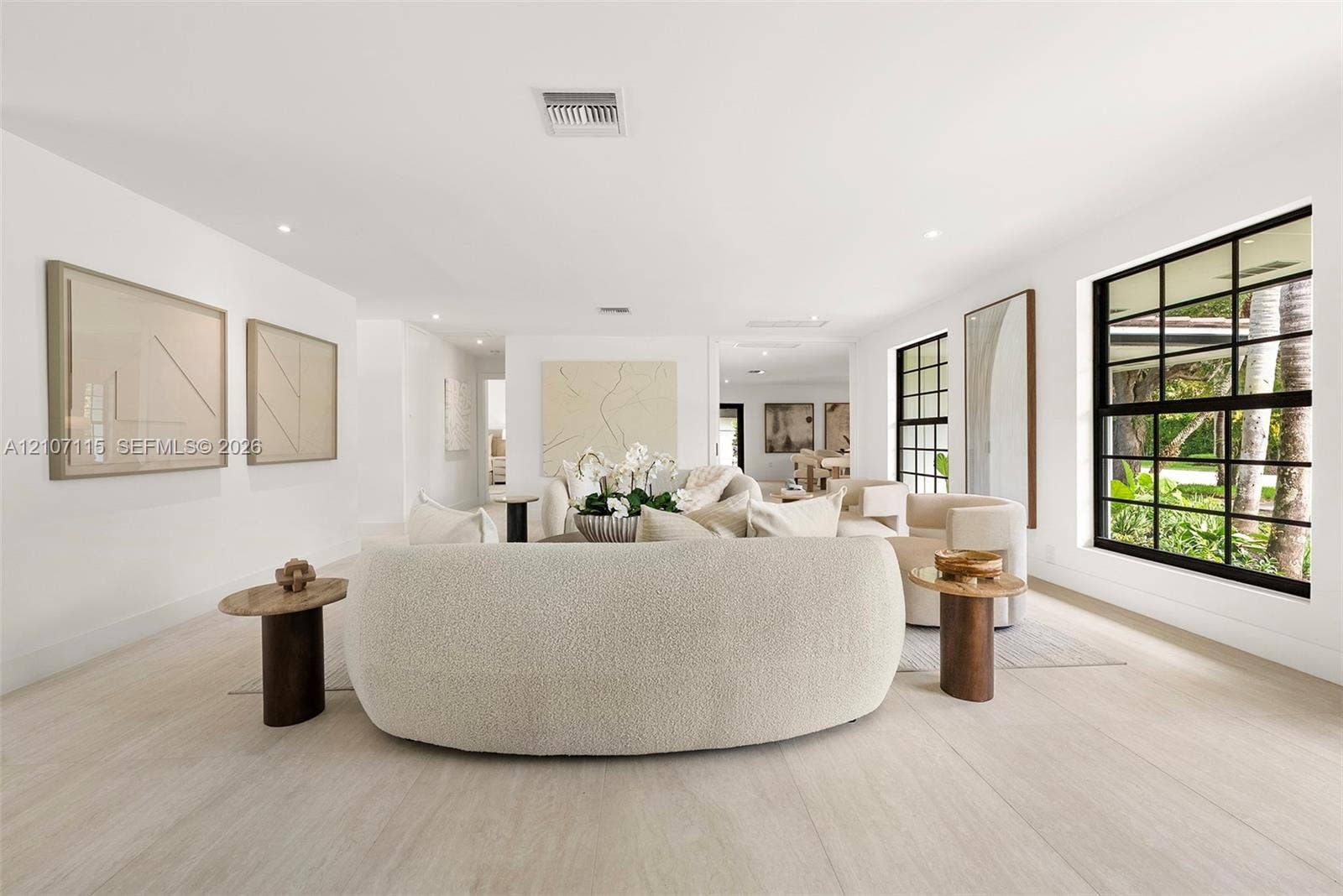 Interior space featuring light-toned flooring, expansive windows with black frames, and recessed lighting