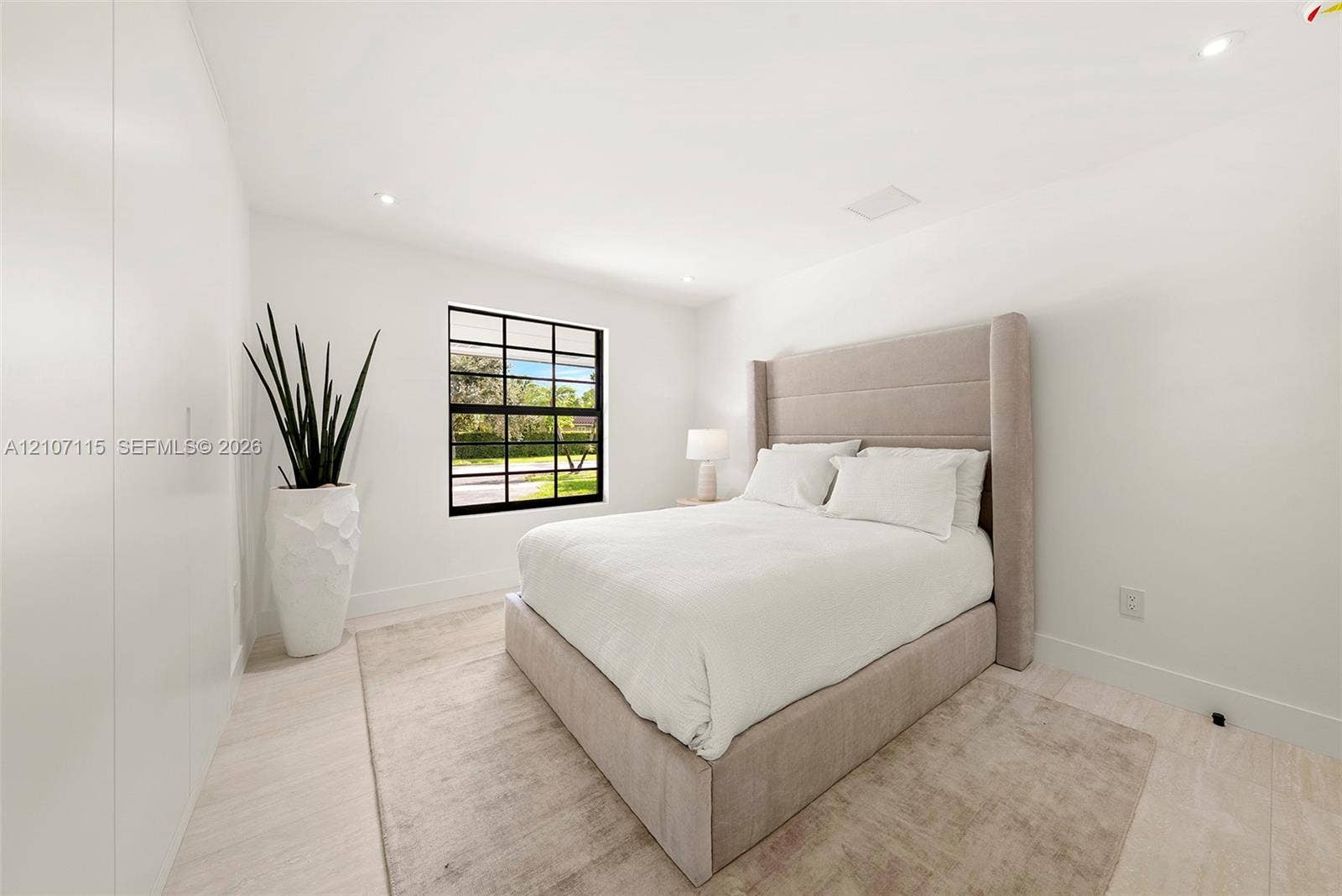 Bedroom 3 Minimalist room featuring smooth white walls, recessed ceiling lighting, light-toned tile flooring, and a black-framed grid window