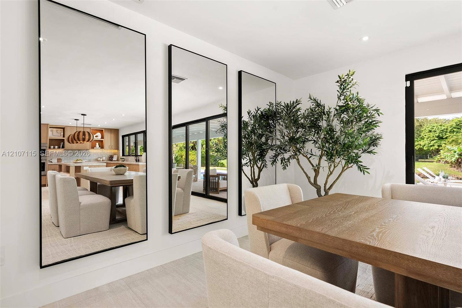 Full-length wall mirrors with thin black frames, recessed ceiling lighting, and large-format tile flooring