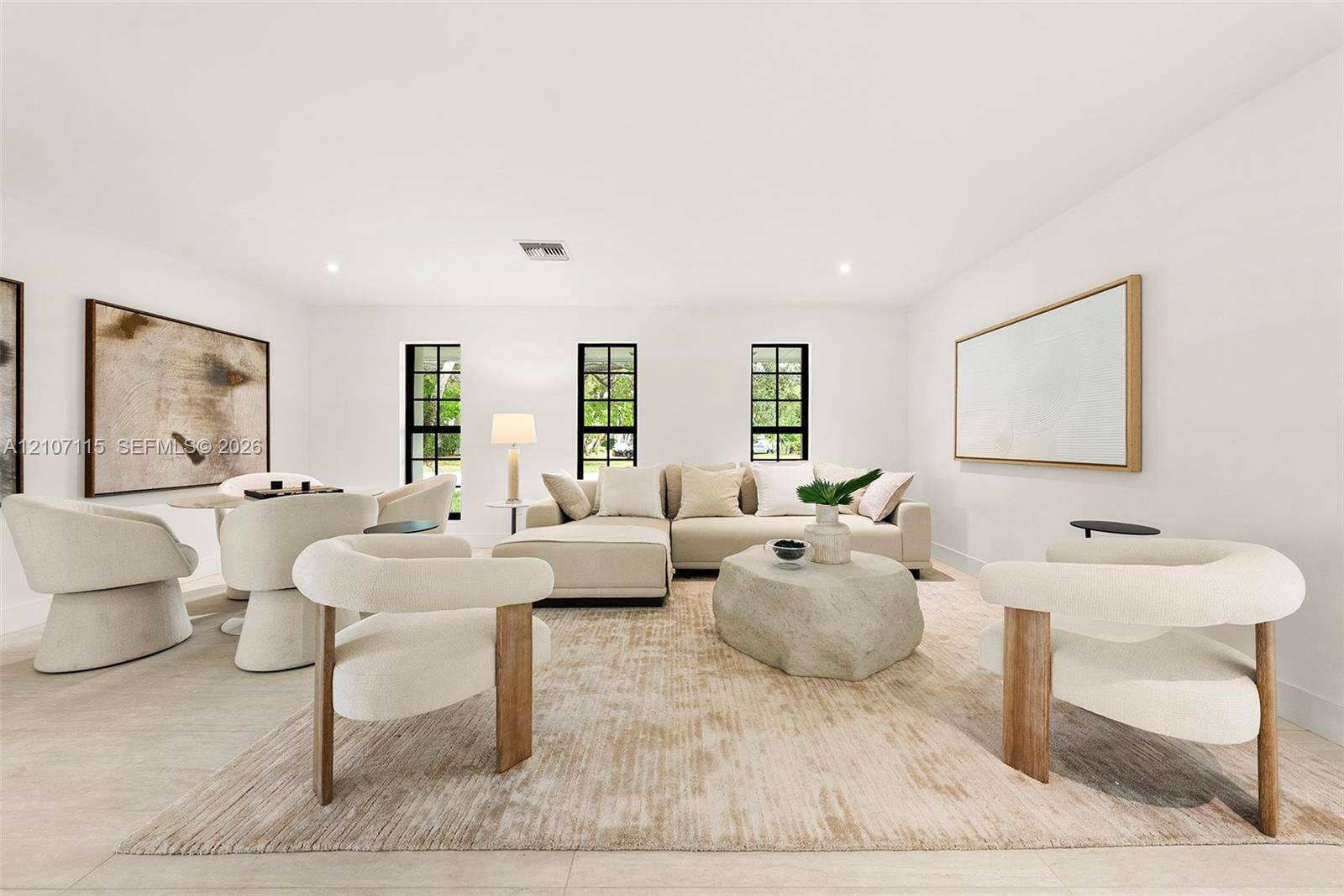 Living area featuring light-toned tile flooring, recessed lighting, and three tall windows with black frames