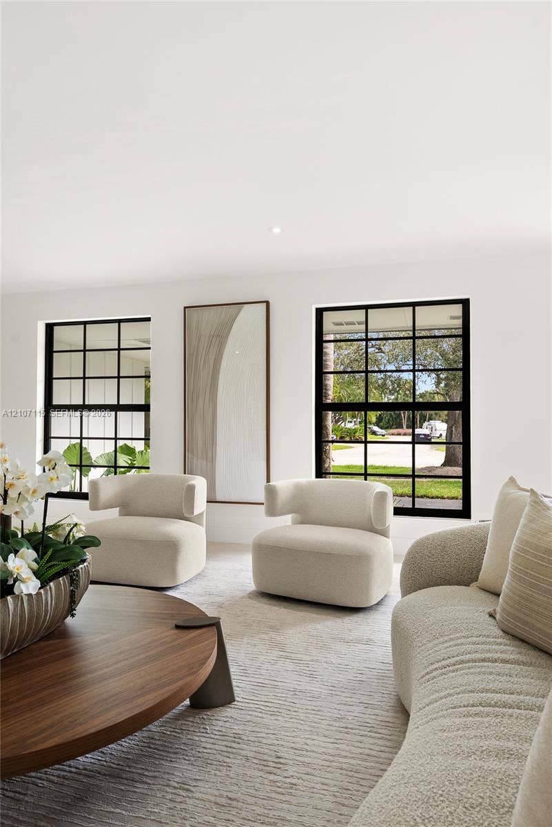 Interior space featuring crisp white walls and grid-patterned windows with matte black frames
