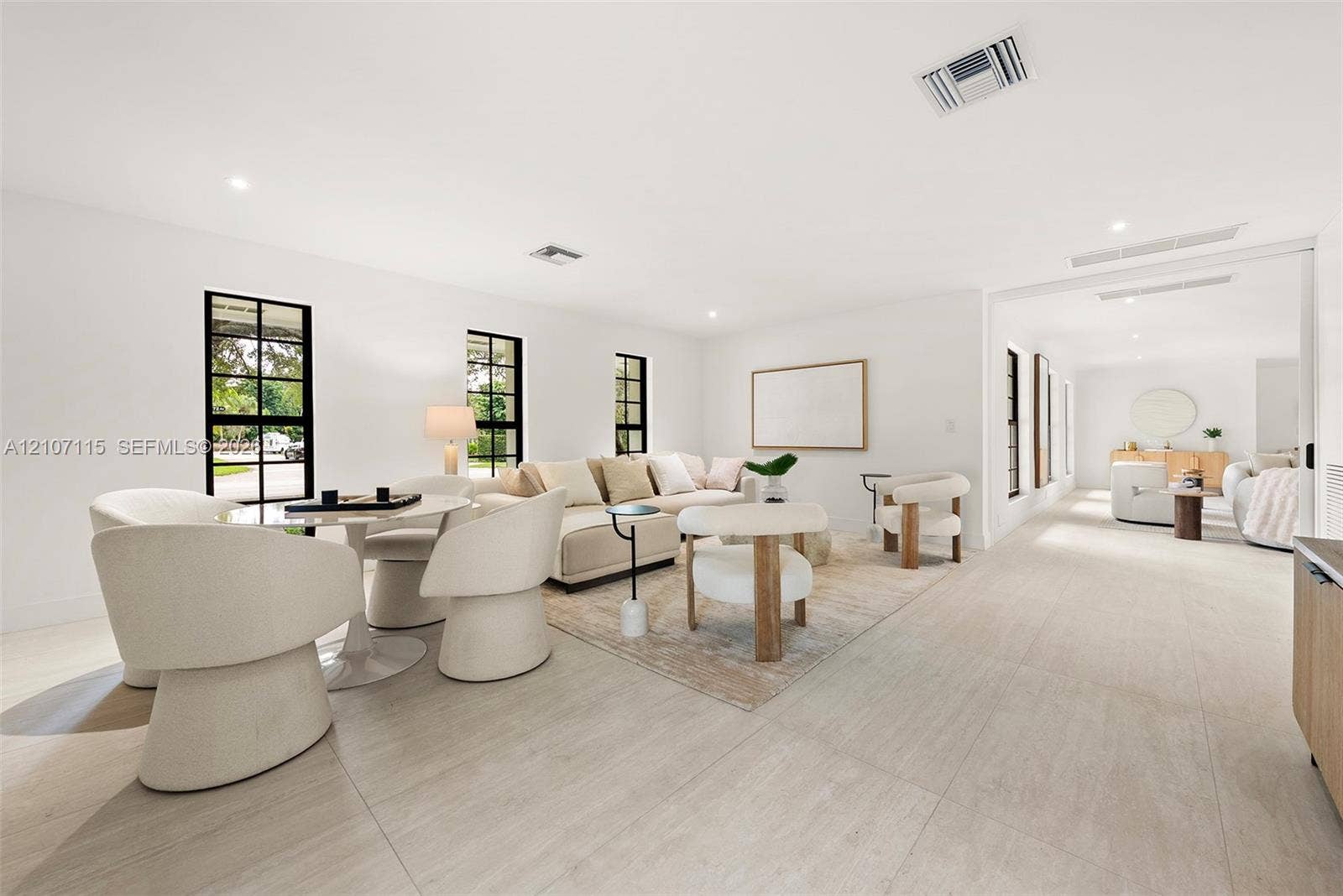 Open-concept interior featuring large-format tile flooring, recessed lighting, and black-trimmed multi-pane windows