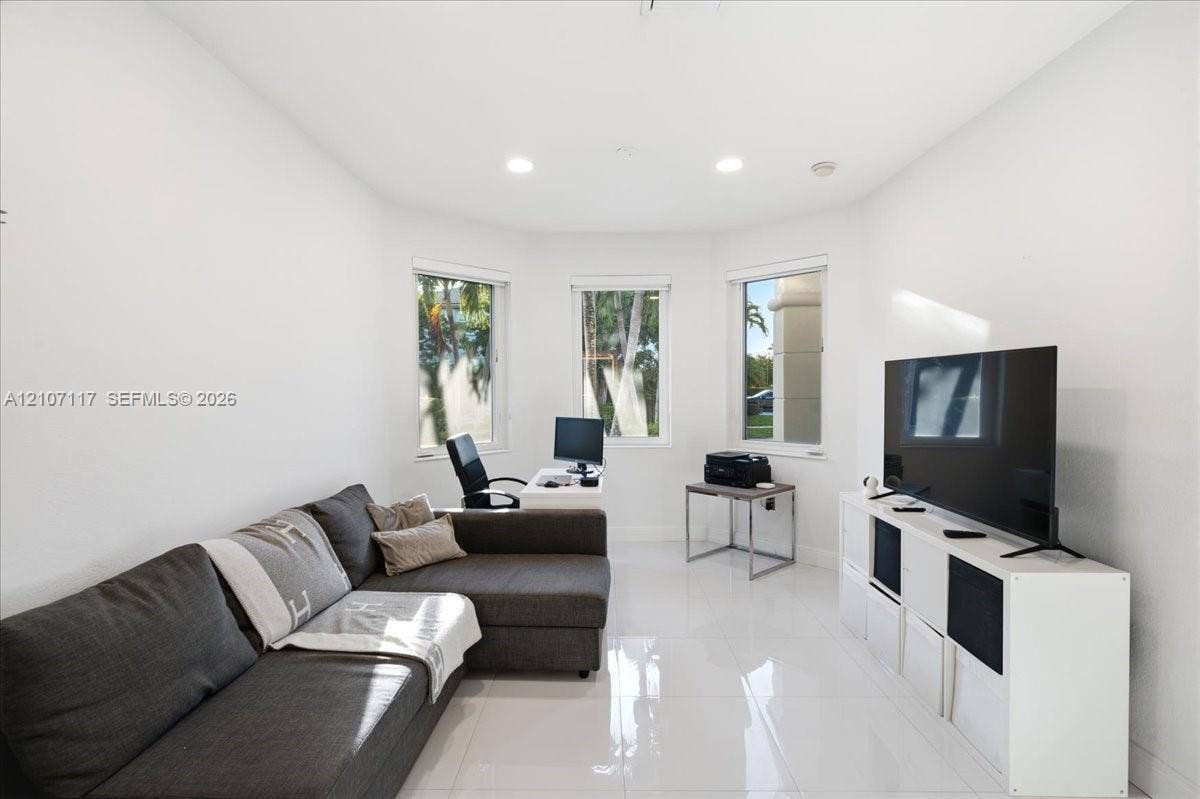 7863 NW 111th Court, Doral, FL 33178 Bright room featuring glossy tile flooring, three large windows, and recessed lighting