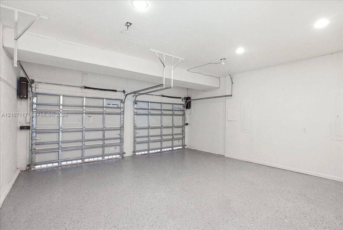 7863 NW 111th Court, Doral, FL 33178 Two-car garage featuring finished epoxy flooring, white walls, and recessed lighting