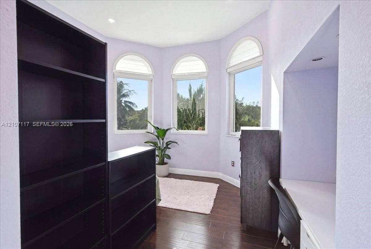 7863 NW 111th Court, Doral, FL 33178 Bay window featuring three arched-top windows and recessed ceiling lighting with dark wood-finish flooring and a built-in desk surface