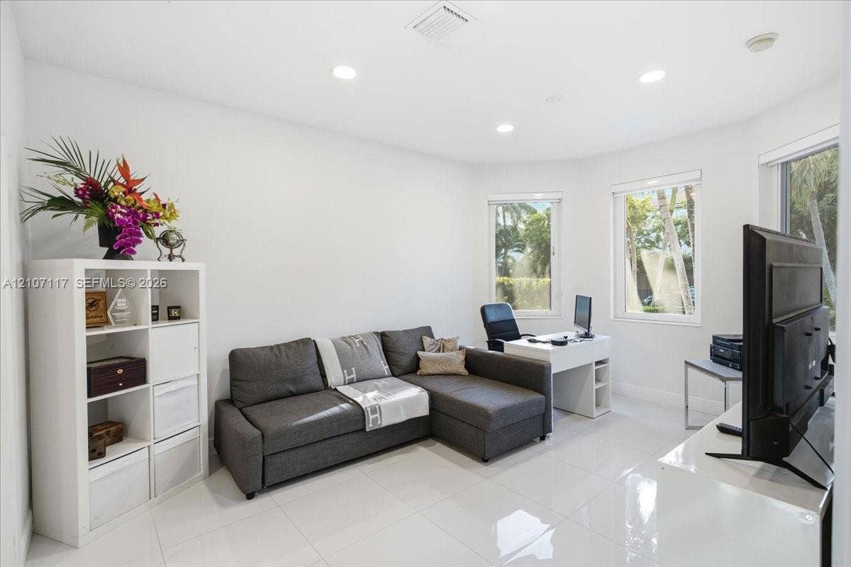 7863 NW 111th Court, Doral, FL 33178 Neutral-toned interior featuring large-format tile flooring, recessed ceiling lighting, and expansive bay windows
